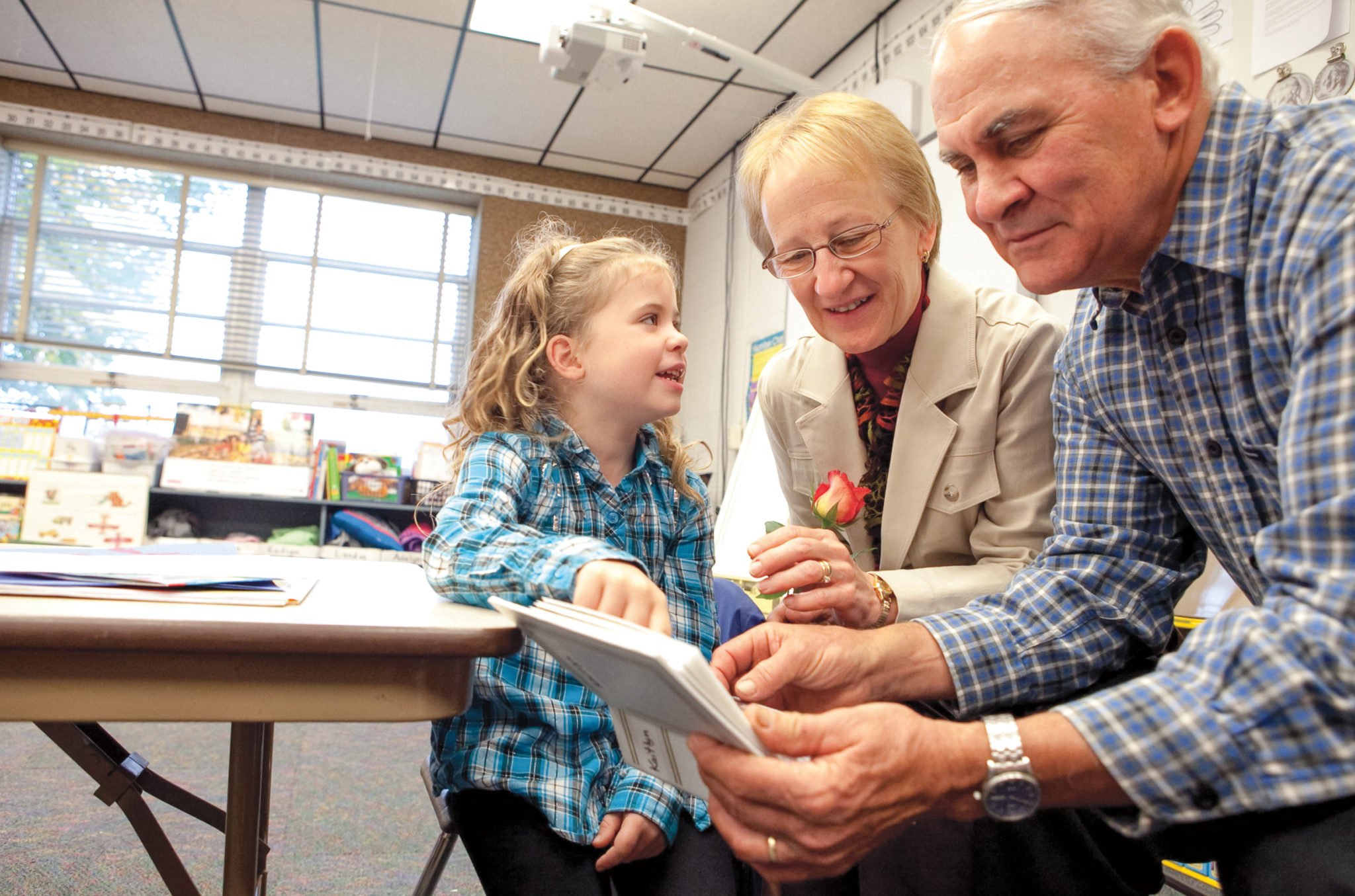 young girl with her grandparents in the classroom