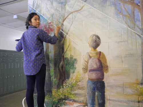 student painting mural