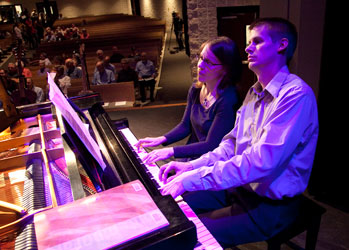 two people playing the piano