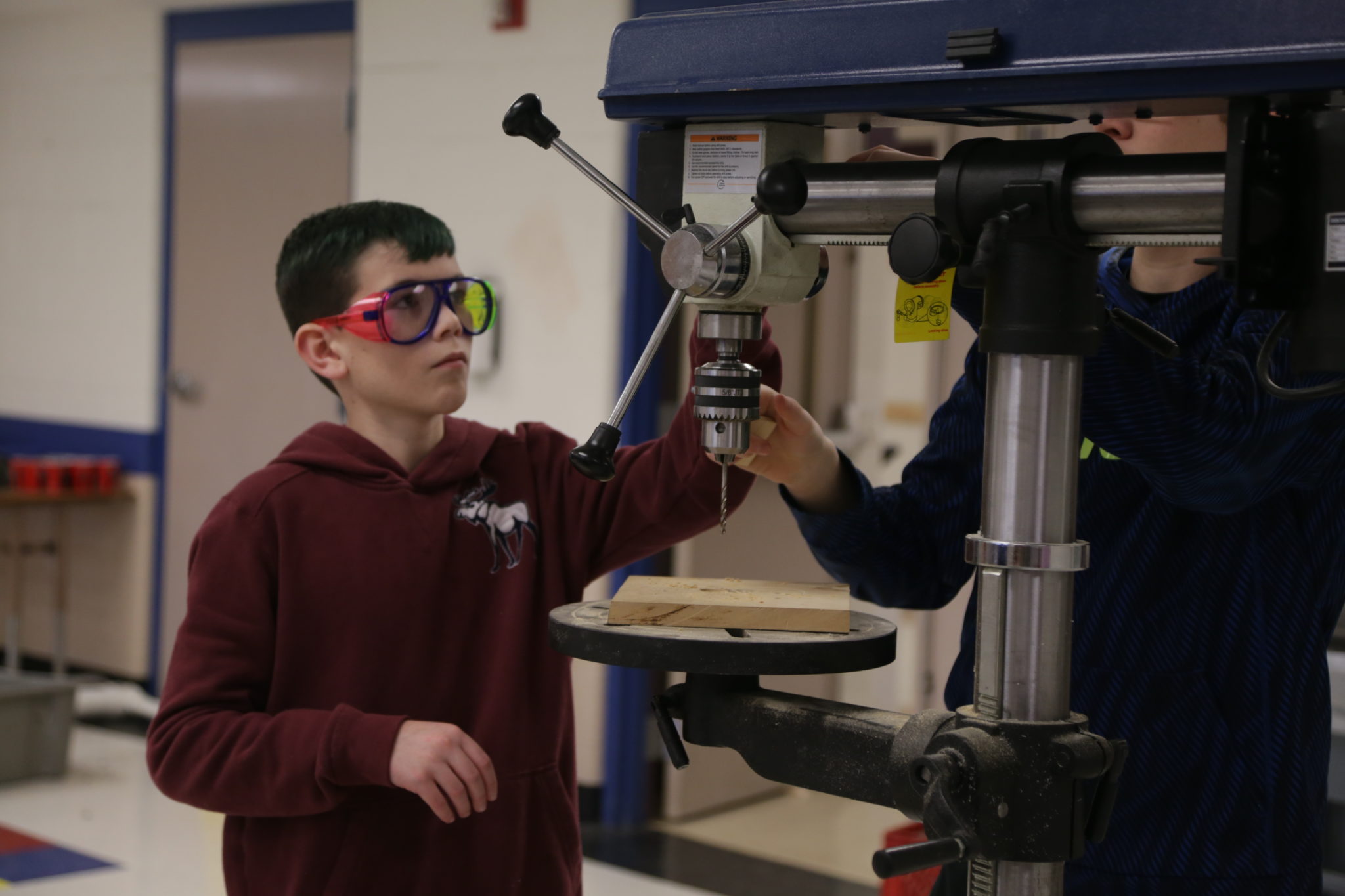 Student using drill in shop room