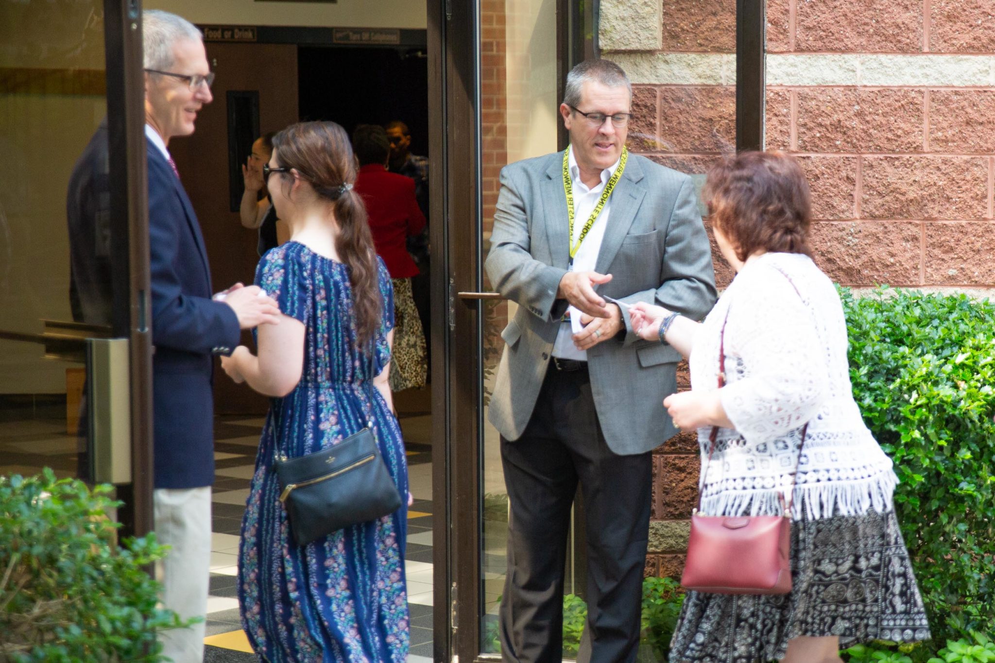 Faculty greeting families going into Fine Arts Center