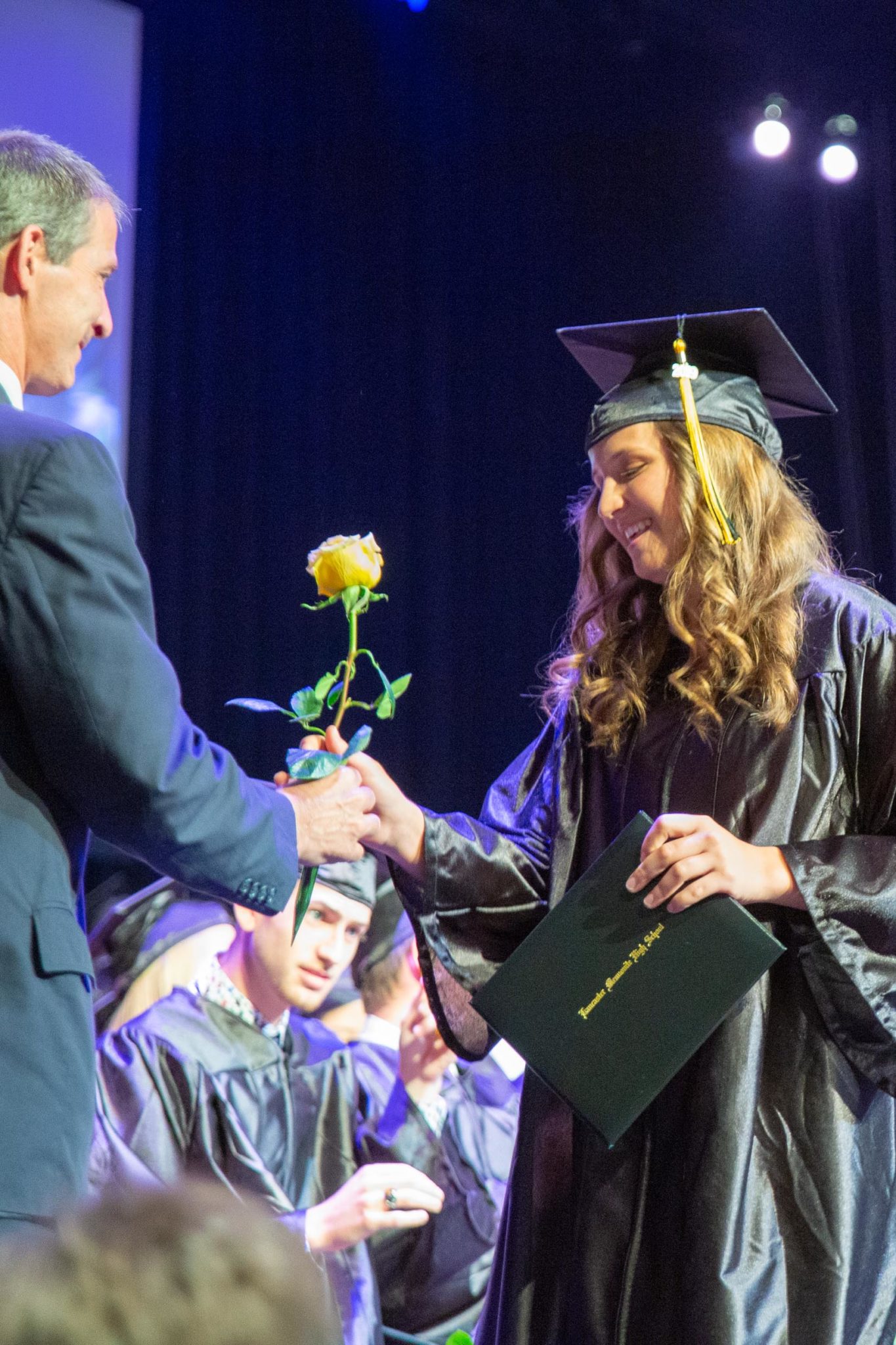 Student receiving rose from graduation