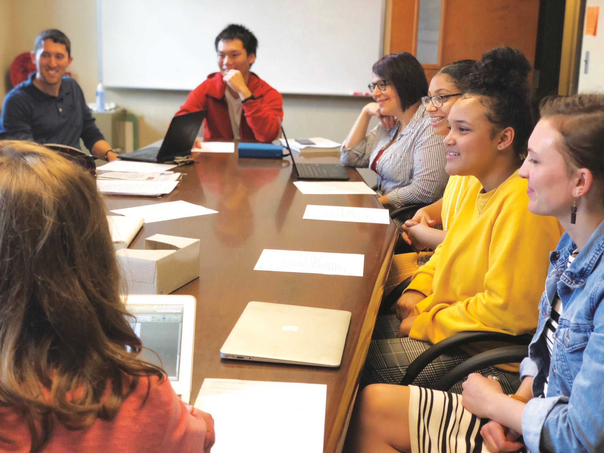 students sitting around table discussing a topic