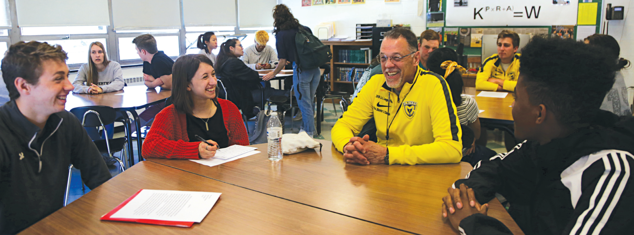 Jim Amstutz and students sitting around tables talking