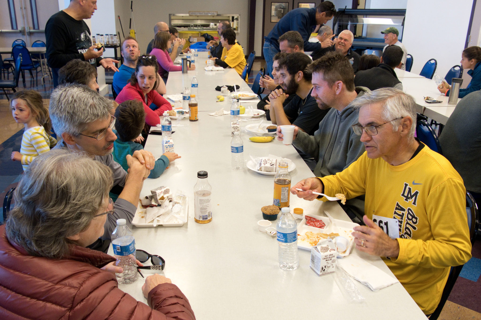 people sitting at long tables eating food