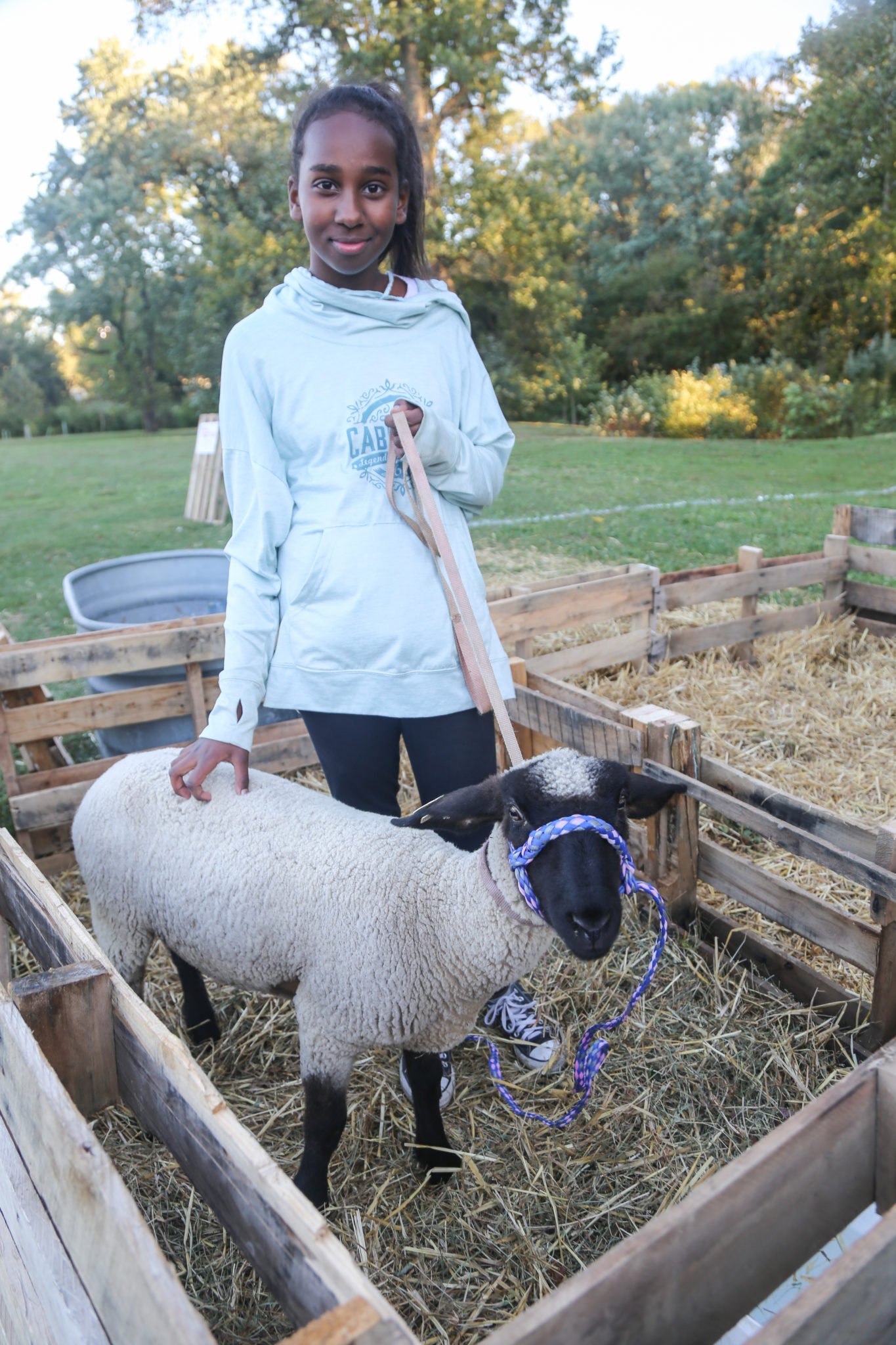 student with lamb at petting zoo during homecoming 2019