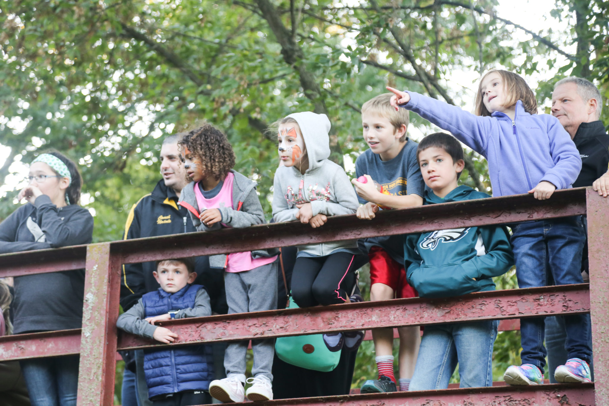 students looking out over bridge above the millstream creek