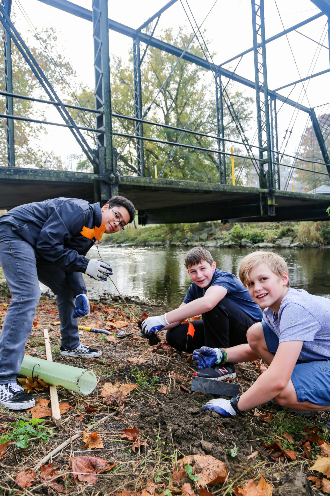 student planting trees on mill stream