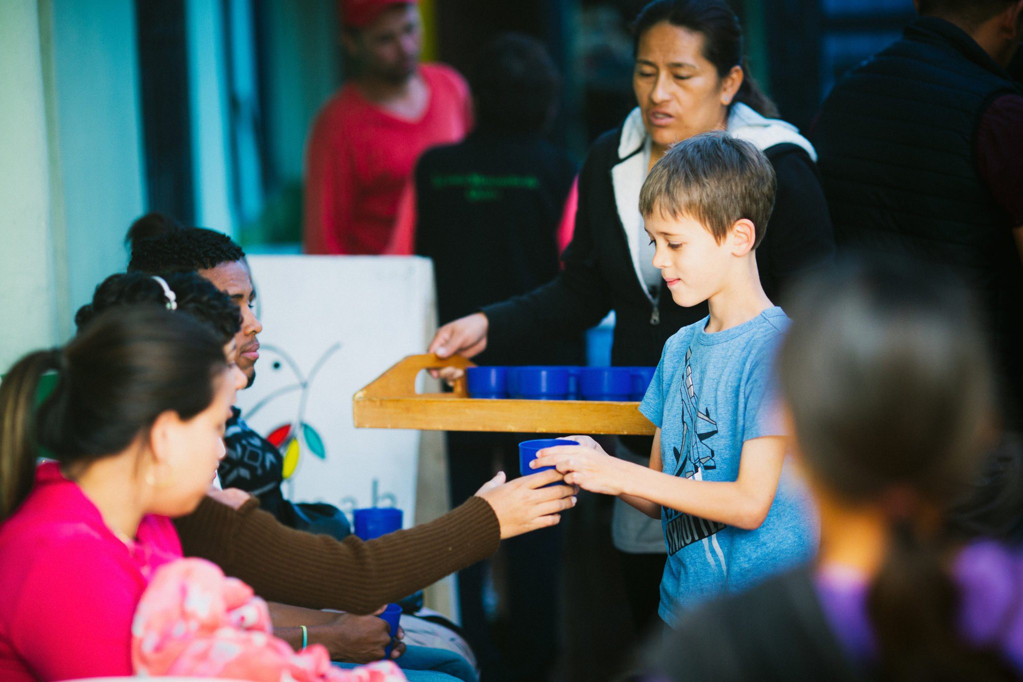 students handing out blue cups to people