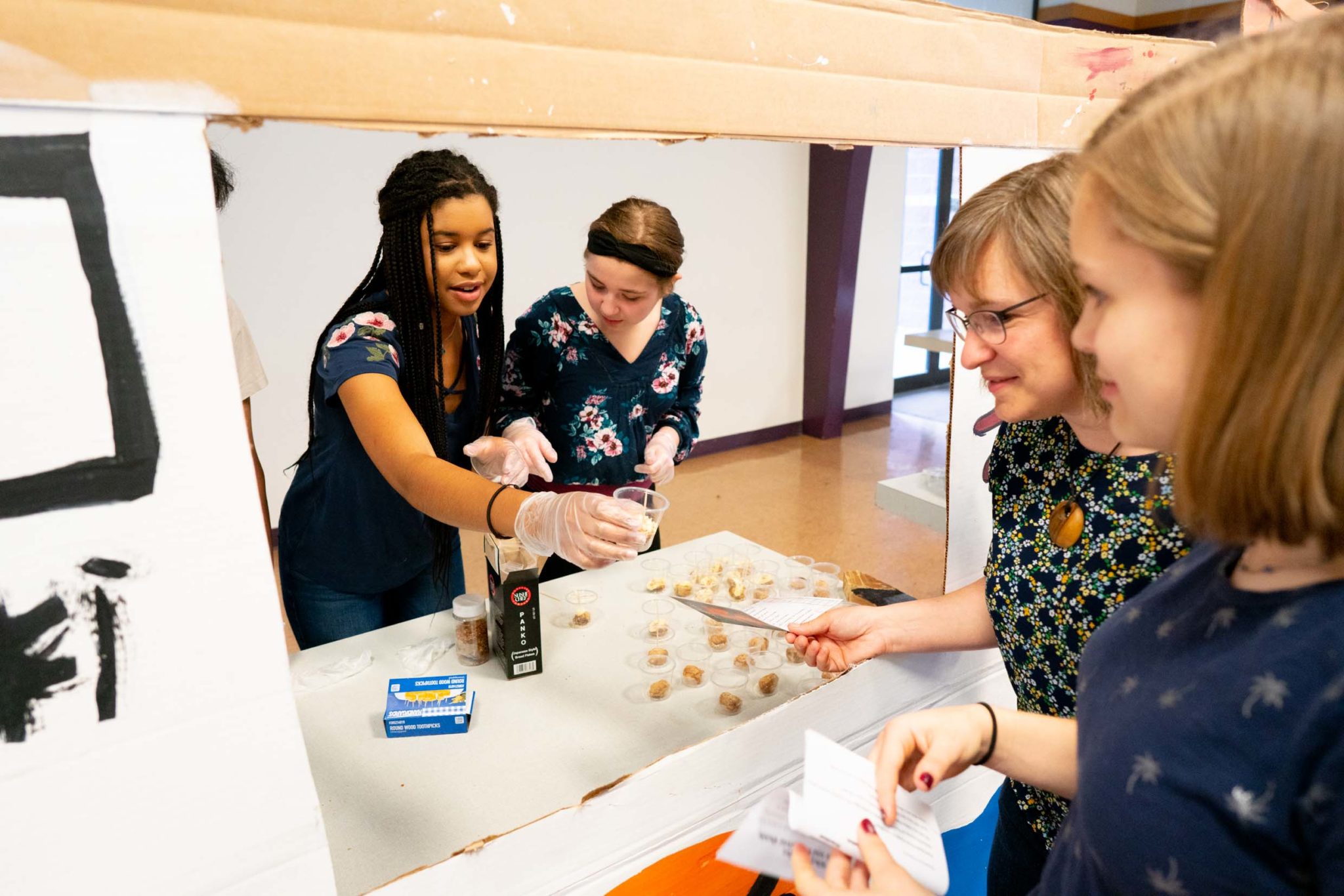 students handing out food at handmade food trucks stands