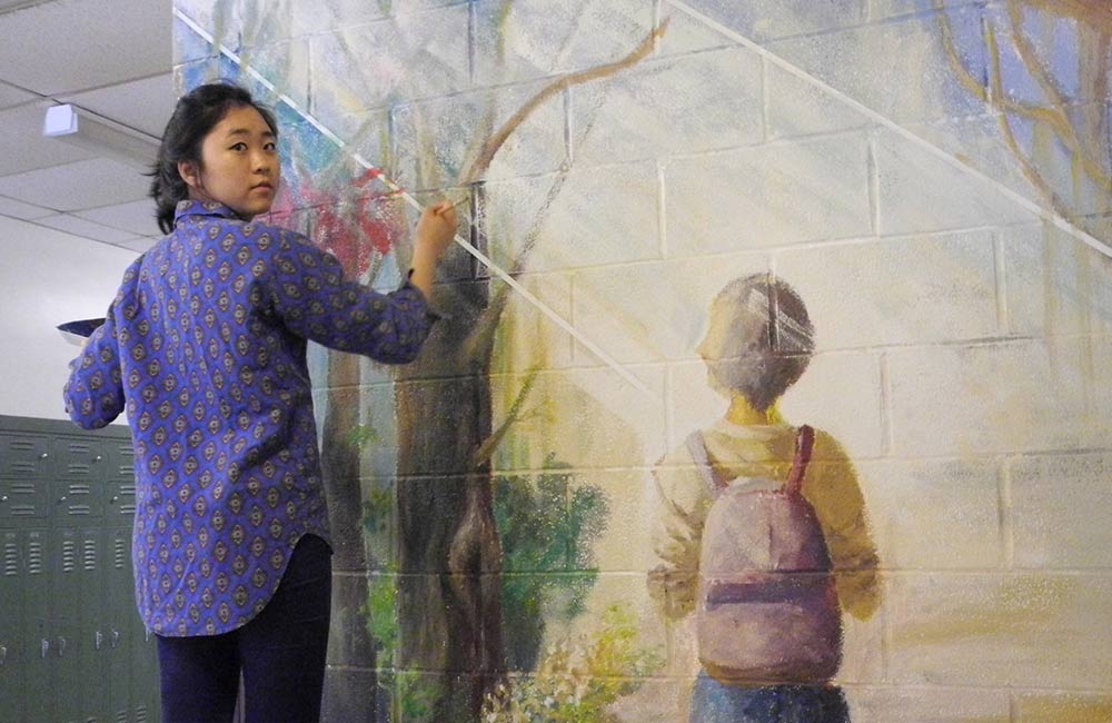 student painting mural