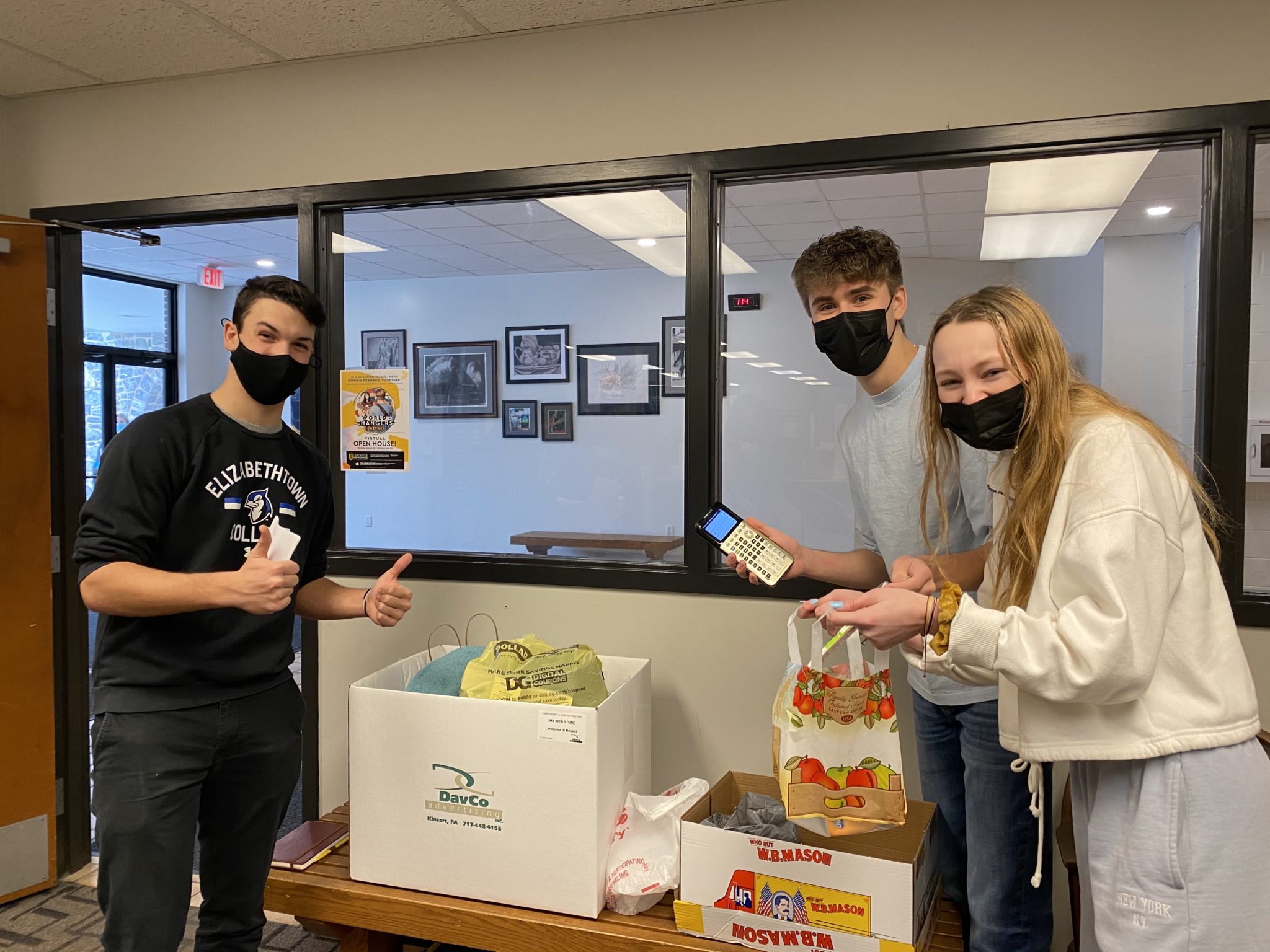 students holding canned goods