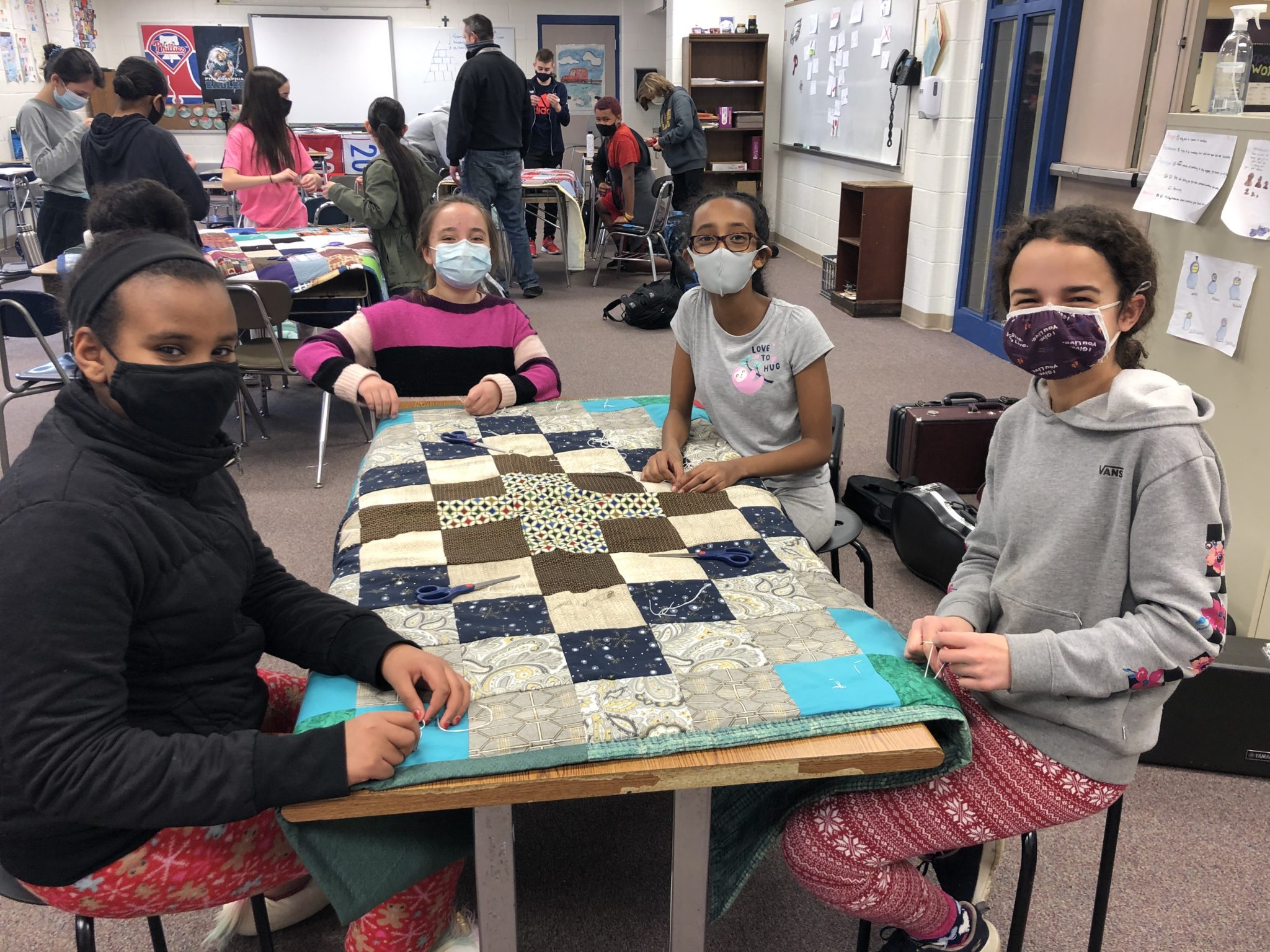 students holding quilts