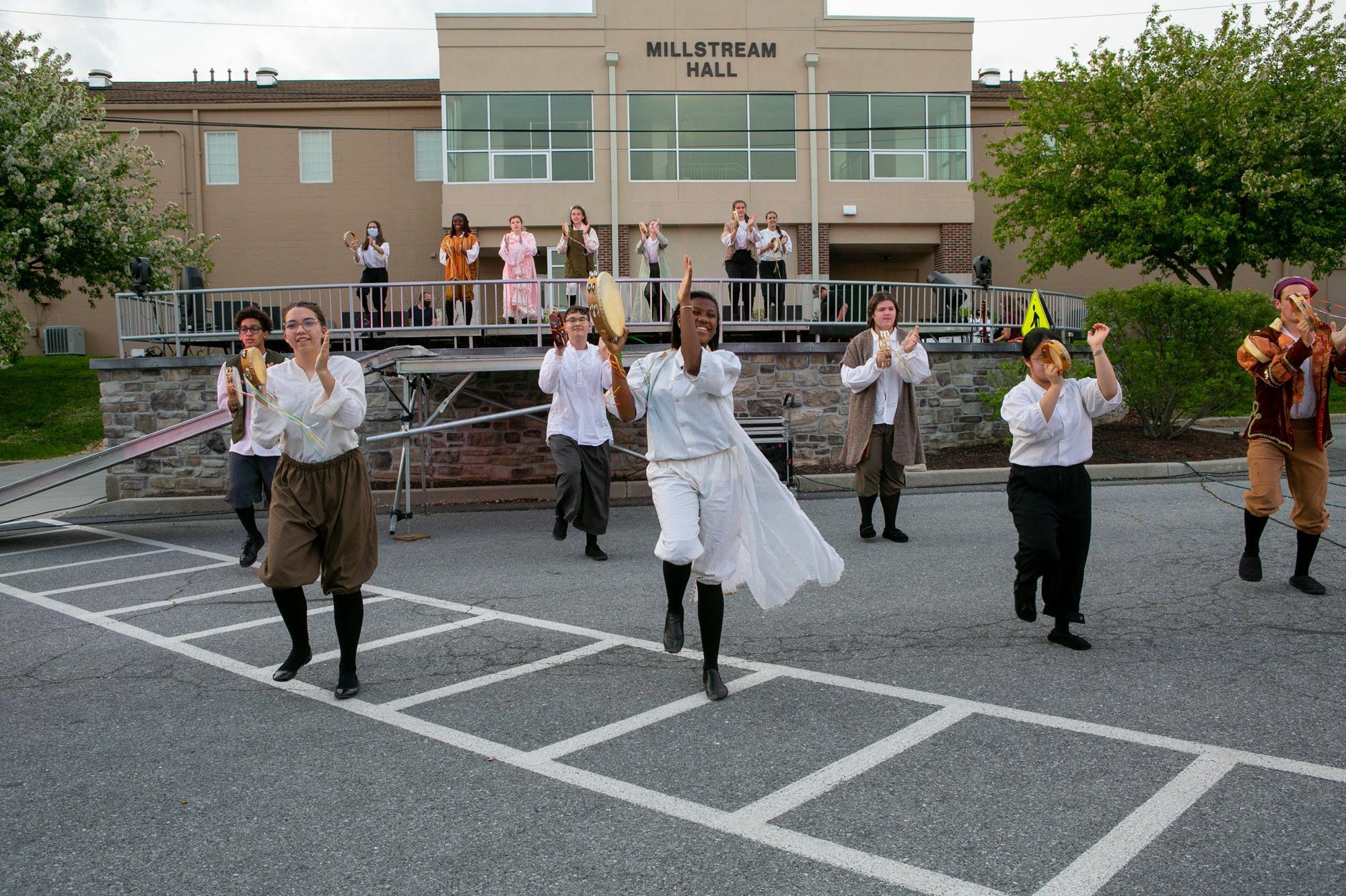 spring drama students dancing and singing outdoors