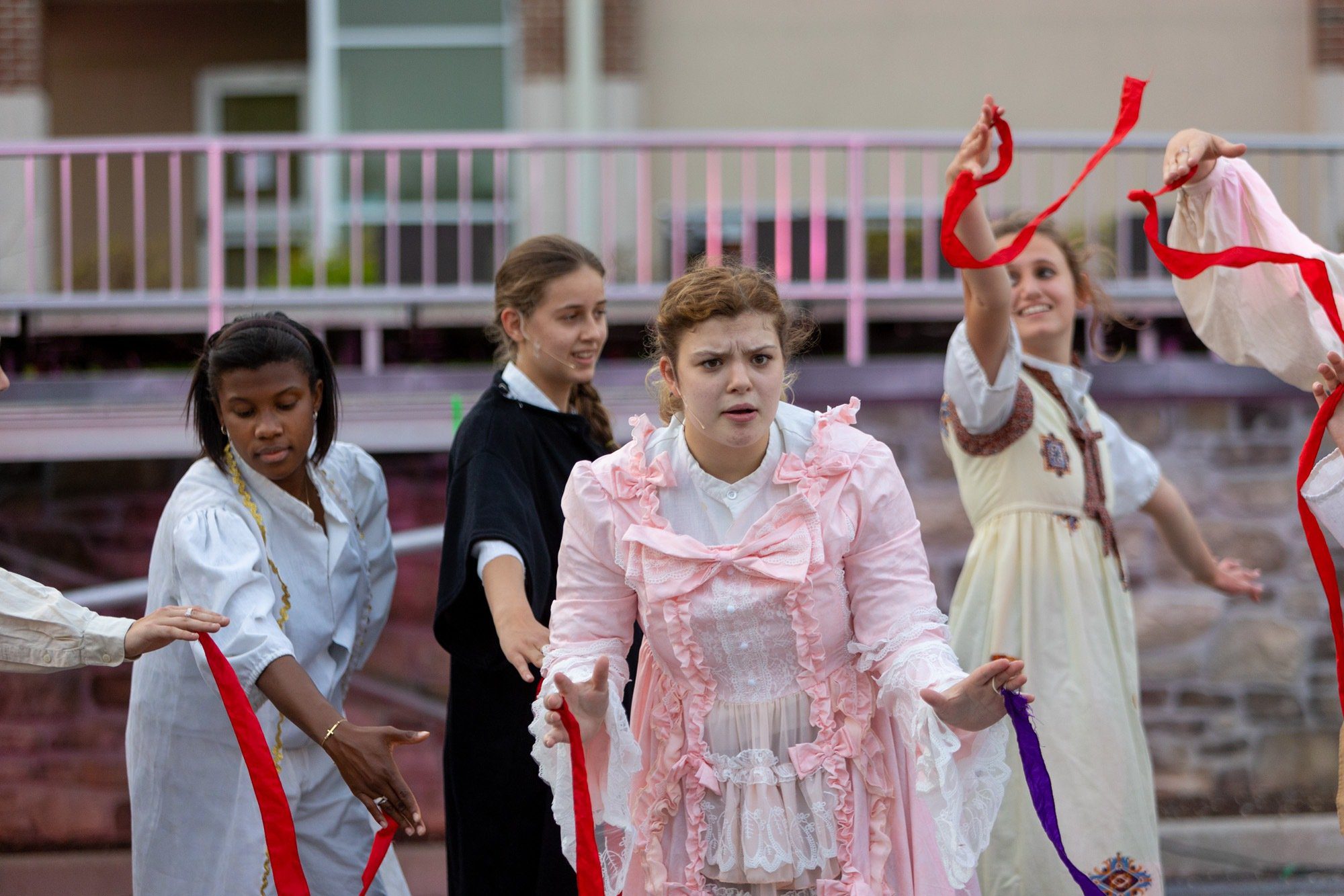 4 girls dancing and acting during the performance of all the worlds a stage