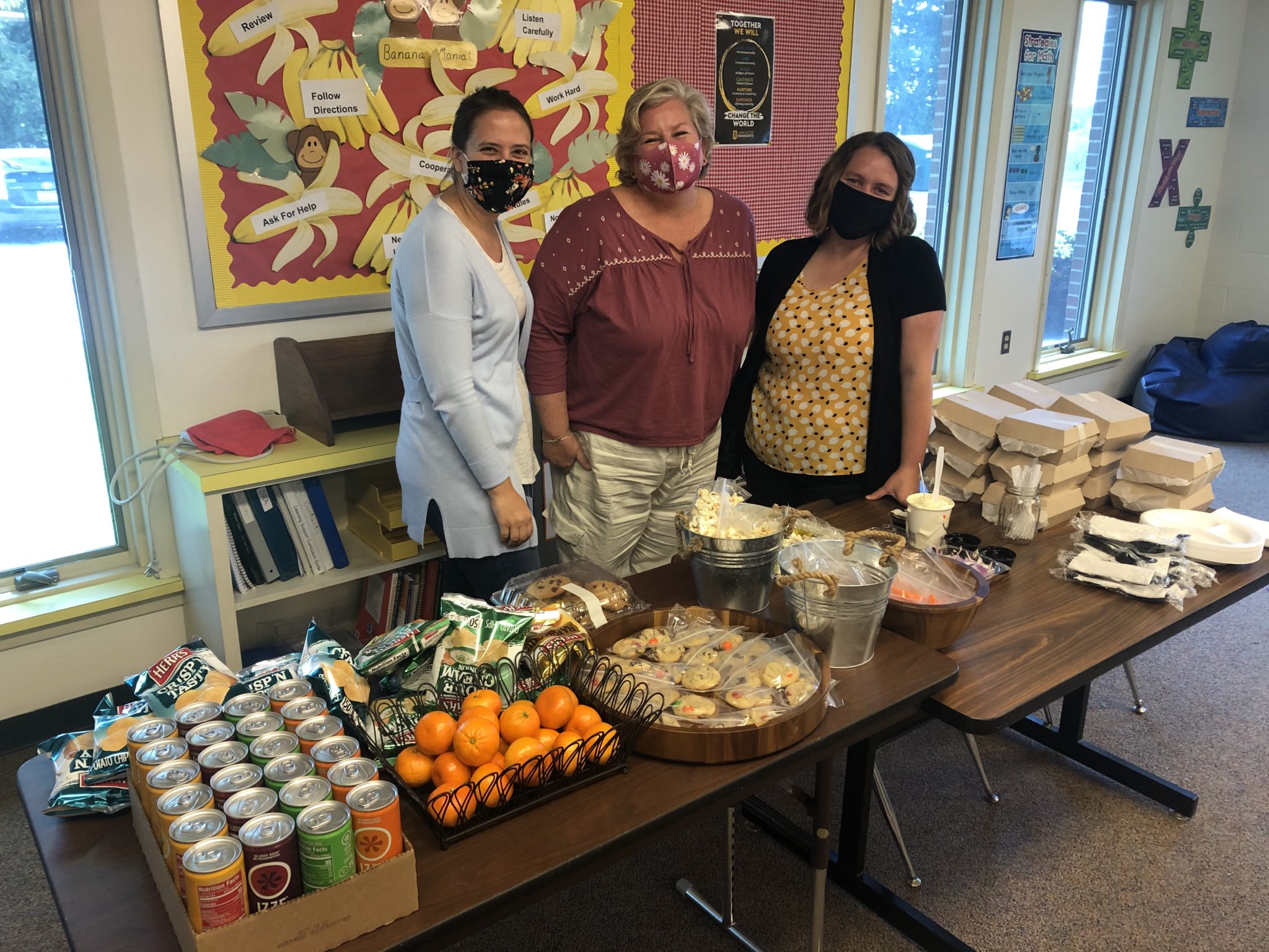 3 women with a table of baked goods