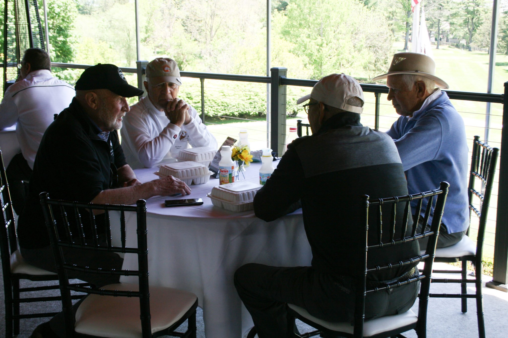 4 men talking around round table