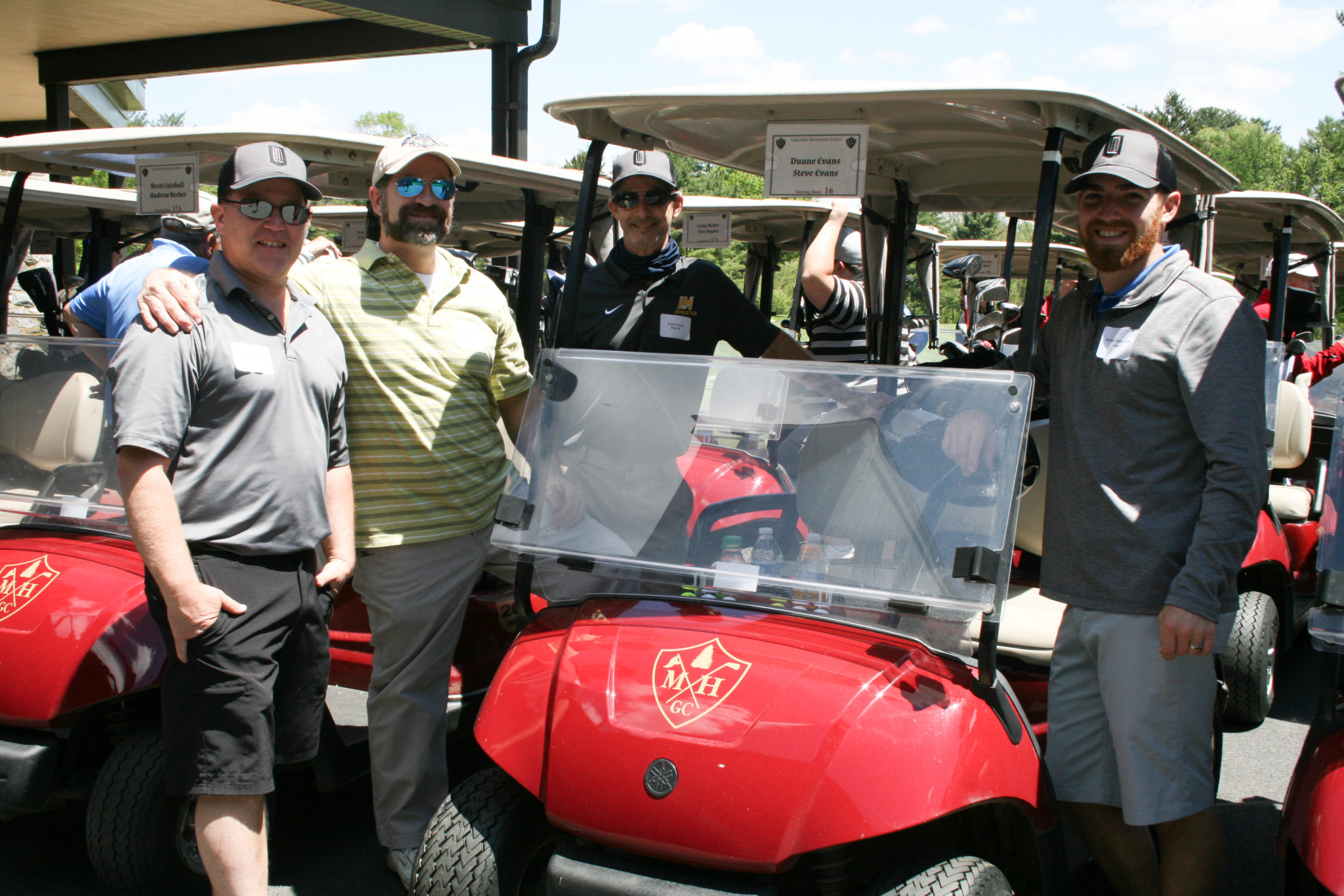 4 male golfers at golf carts