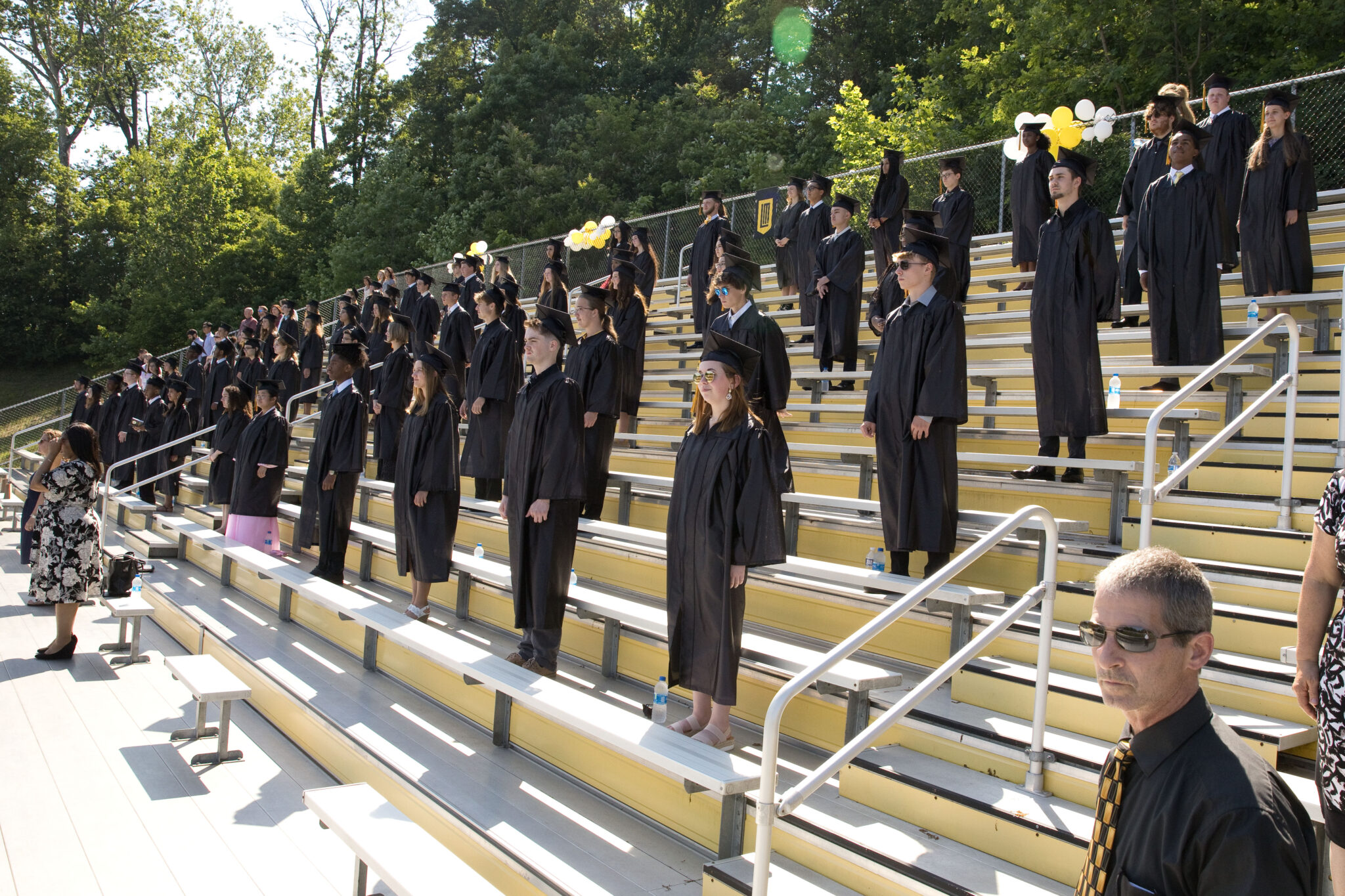 graduates sitting in bleachers during commencement service