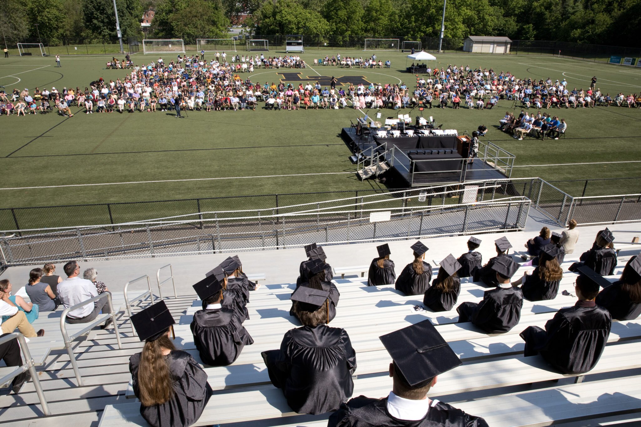 graduation service from bleachers into turf field view