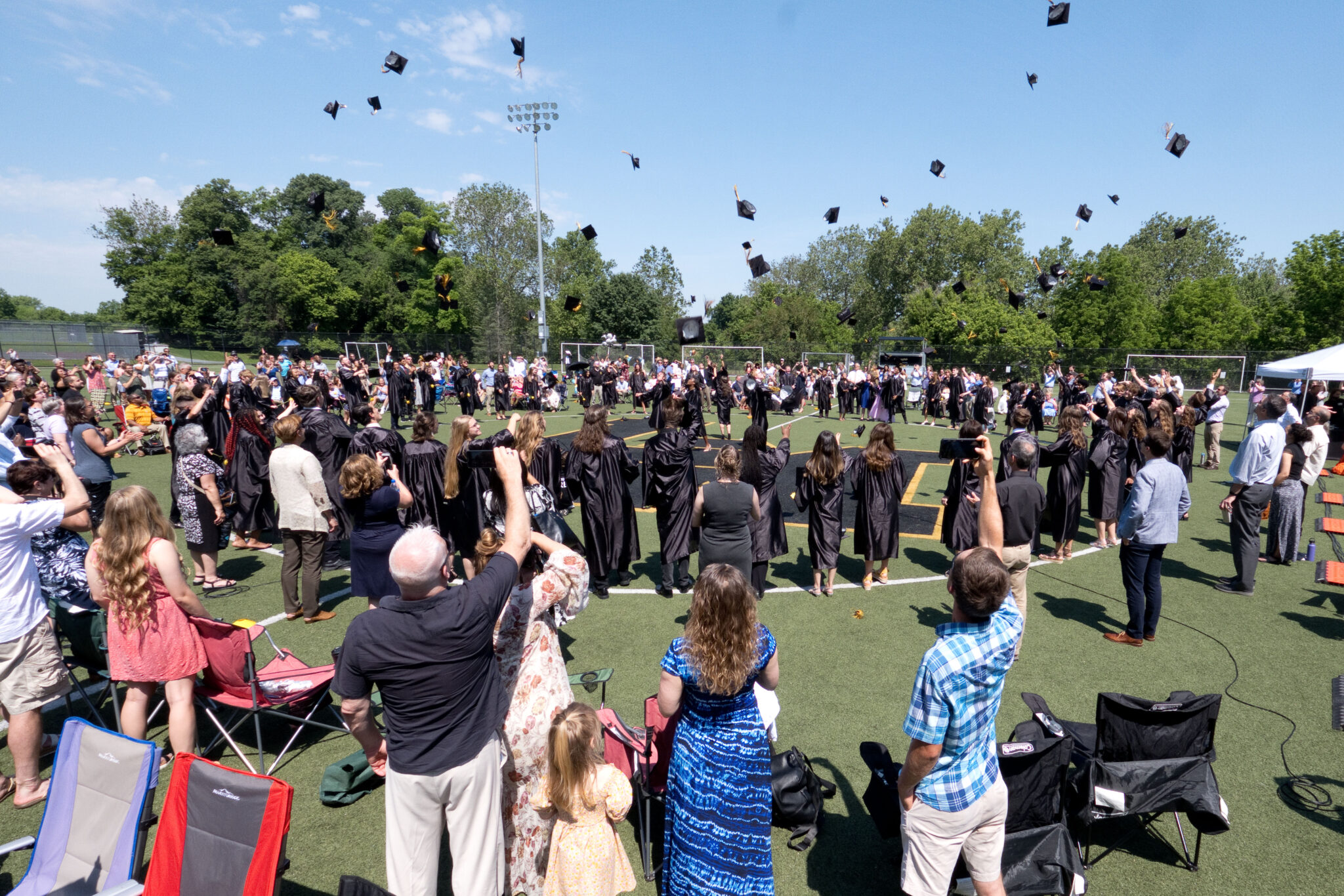 graduates throwing caps commencement