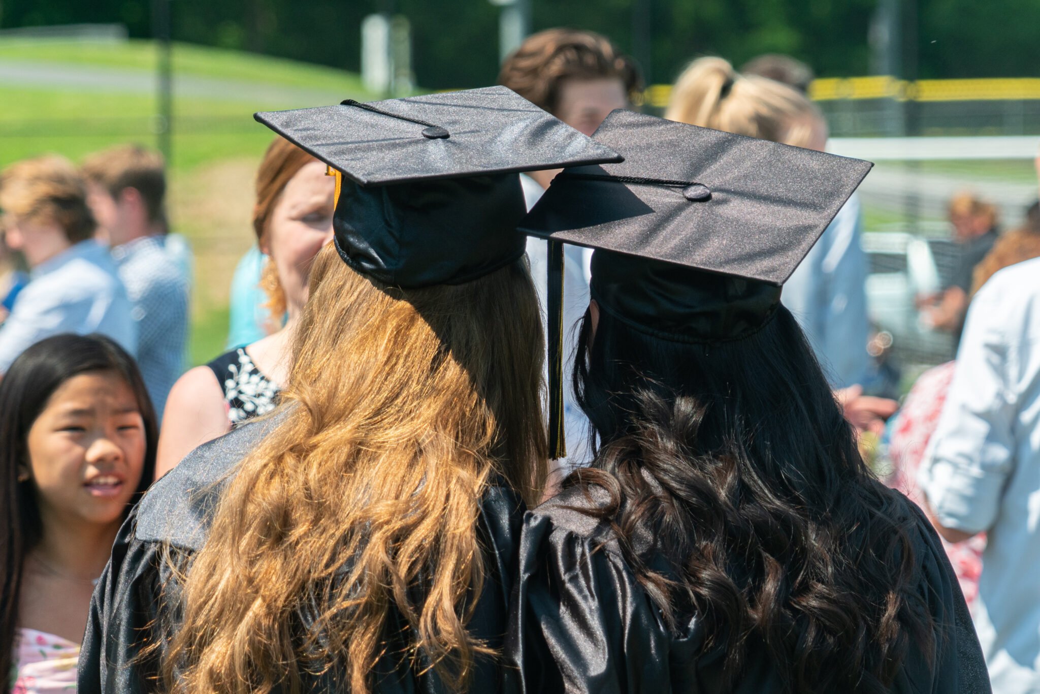 Two graduates with backs to the camera