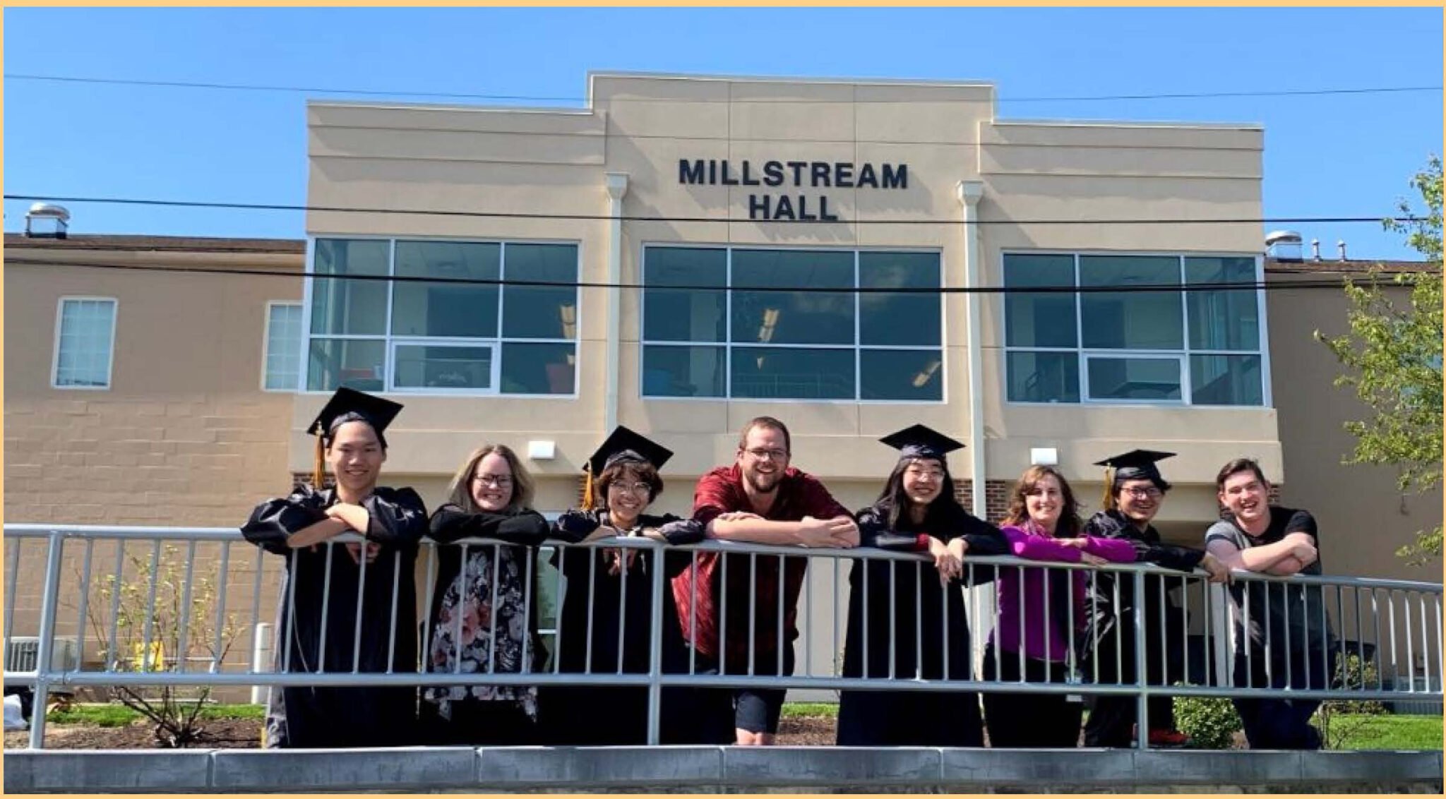 graduates and dorm advisors standing in front of dorm