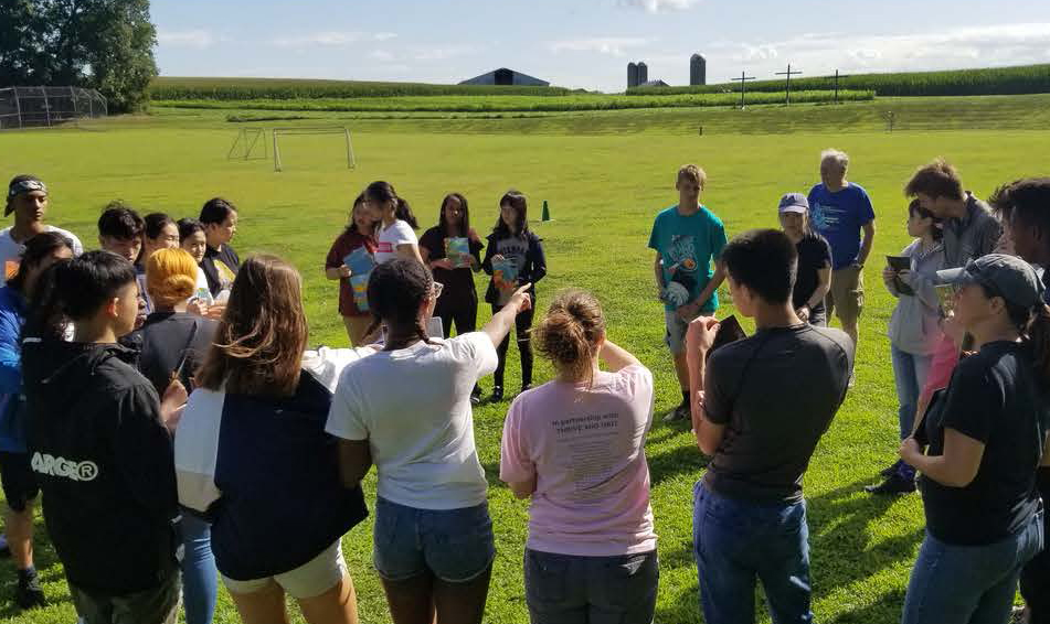 students outside in a circle doing an activity