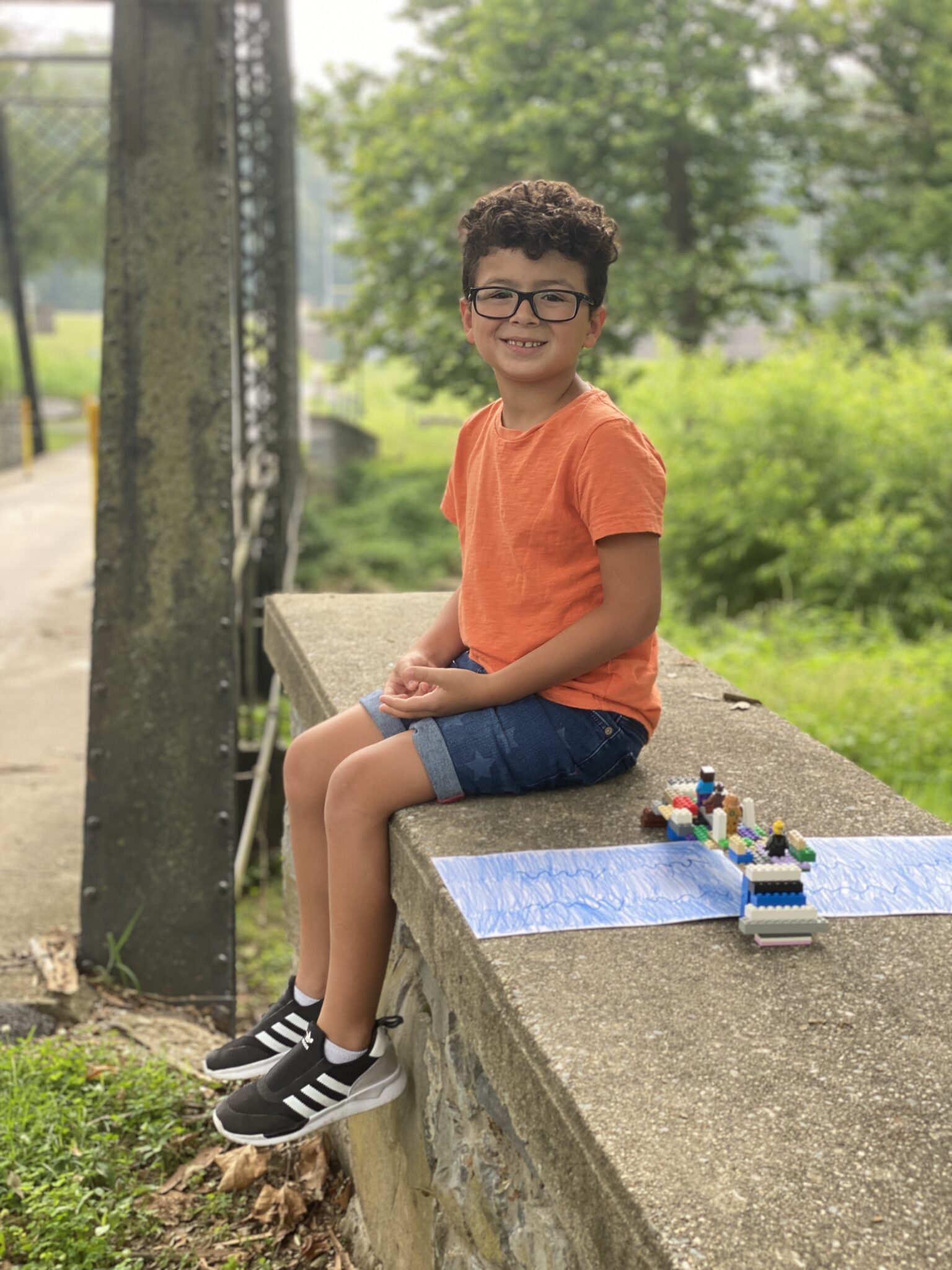 student on bridge with lego bridge creation