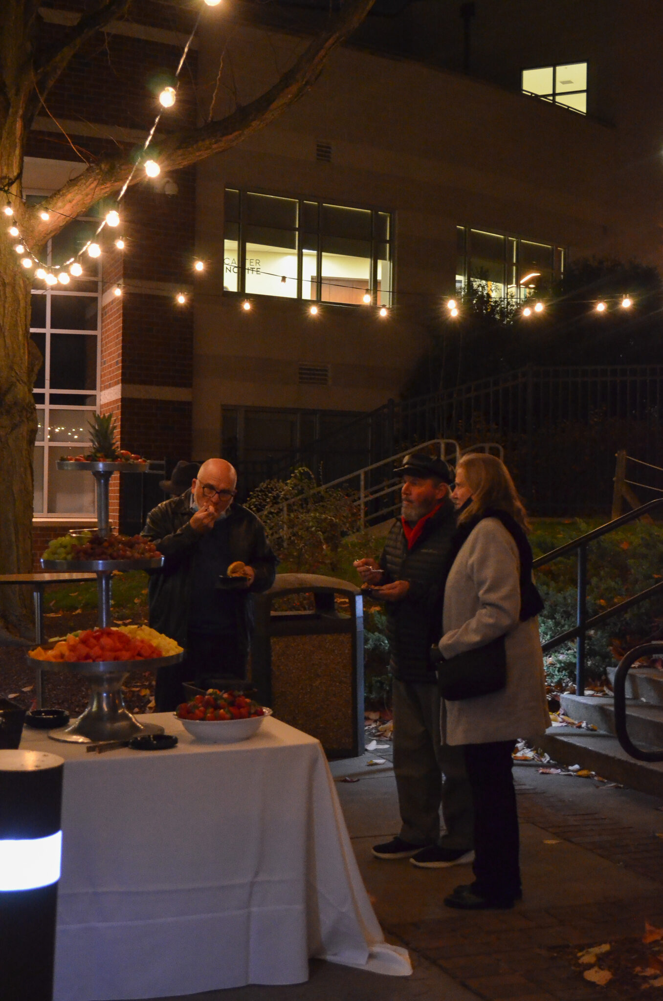 three people eating at fruit table