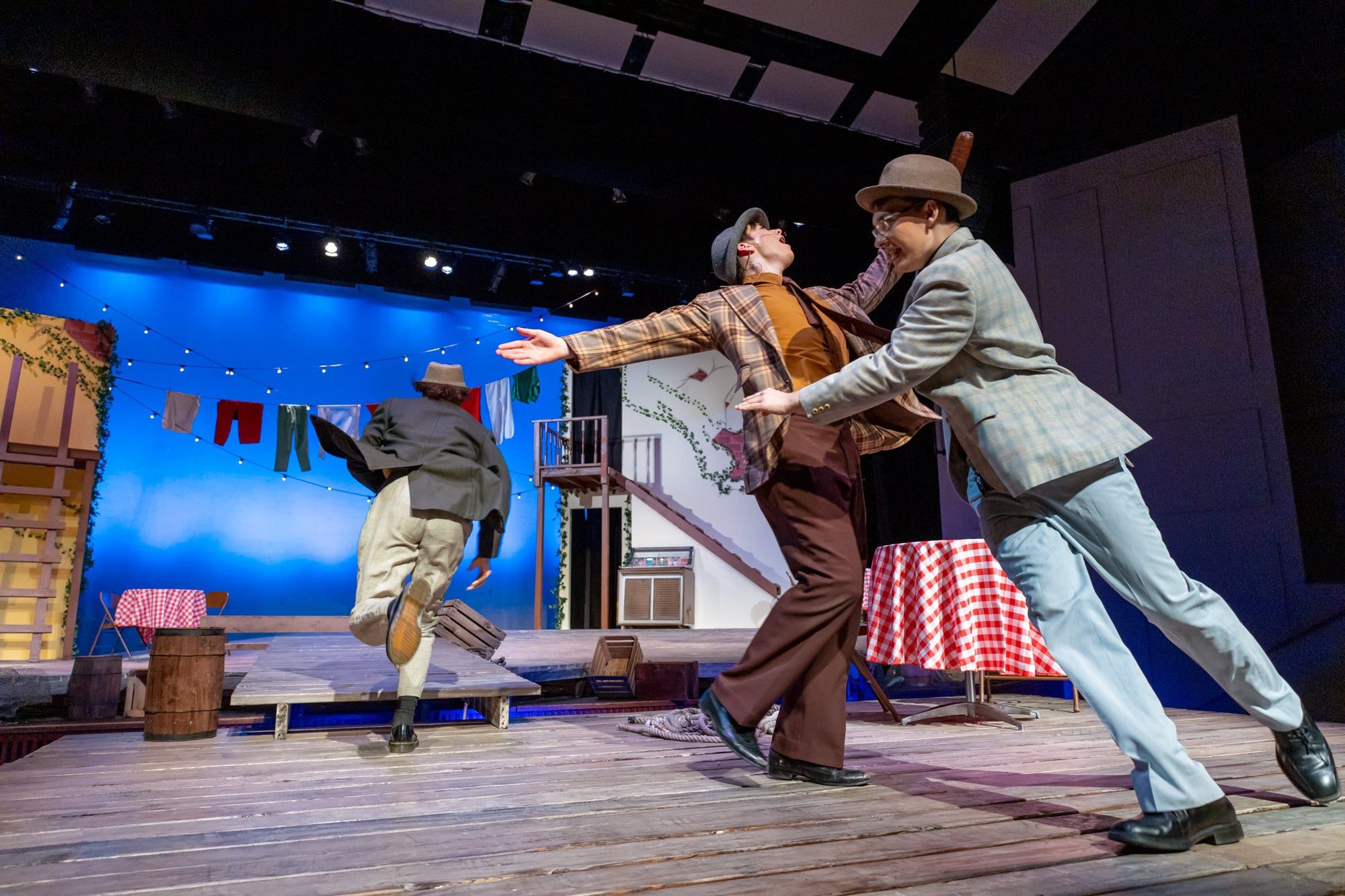 three actors dancing on stage