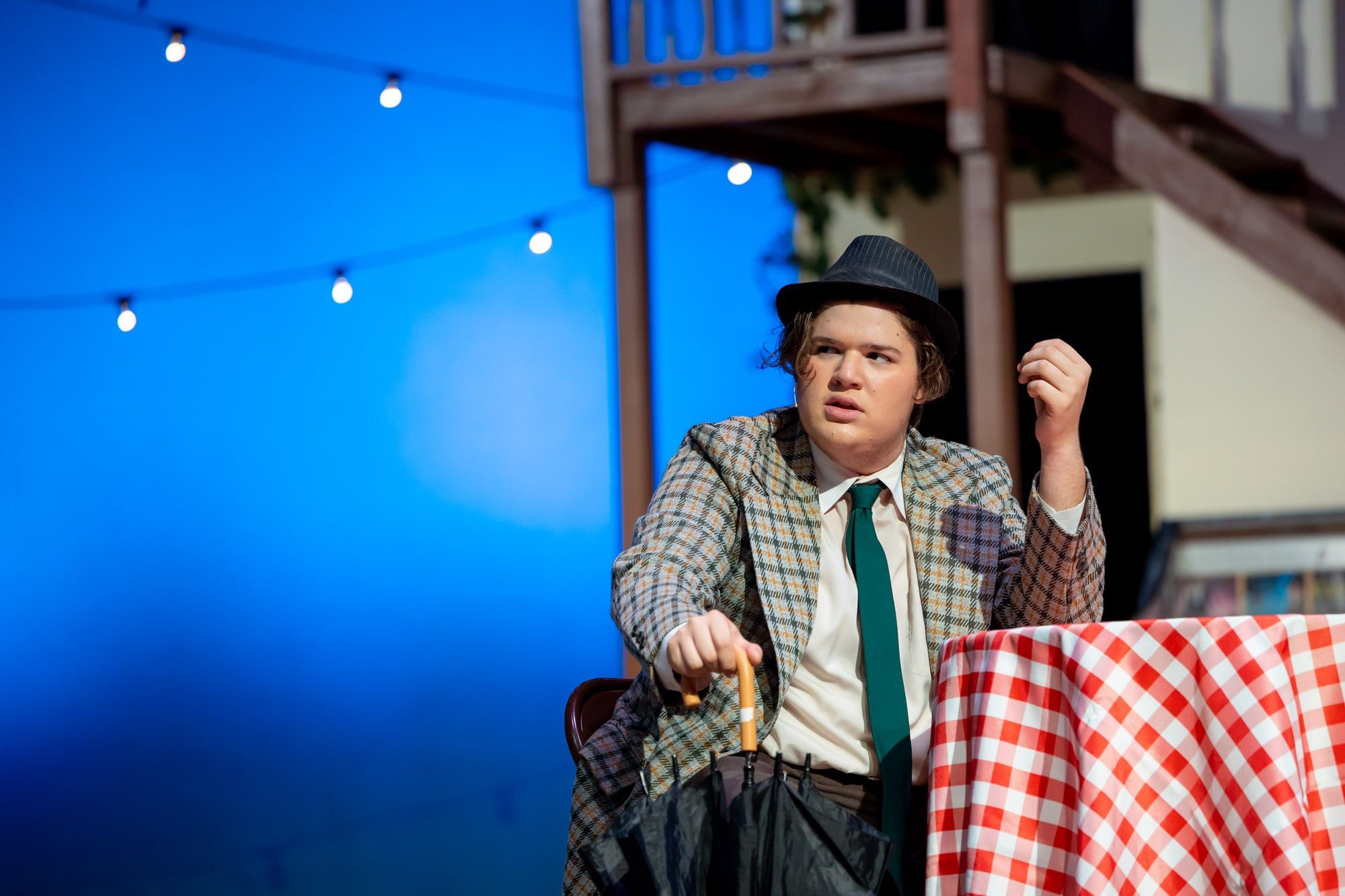 student sitting at a table on stage