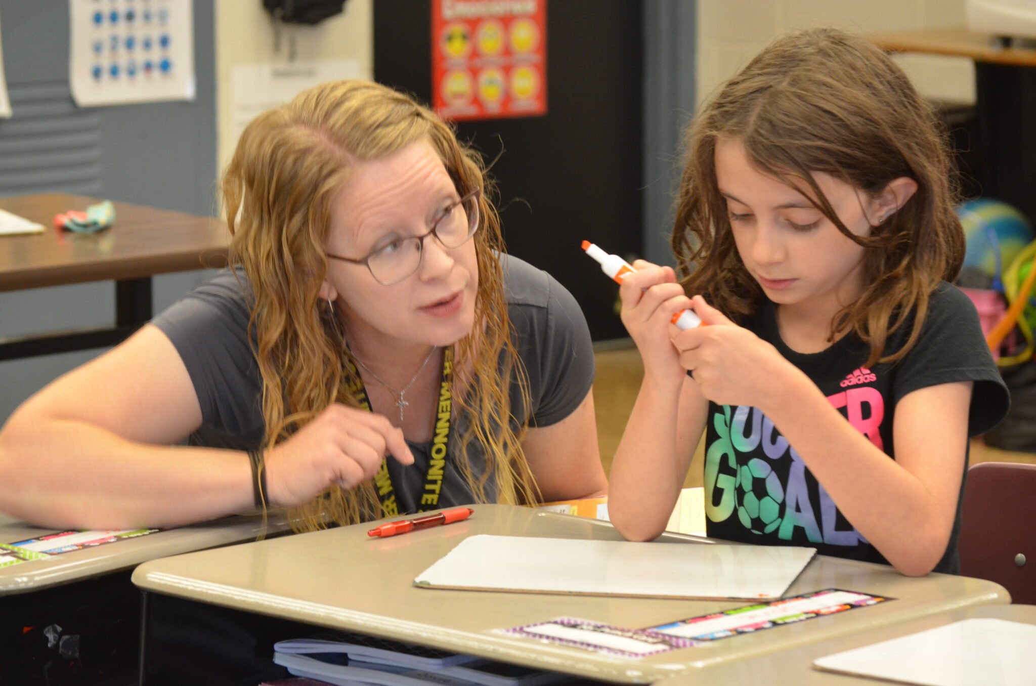 young child and teacher at a desk