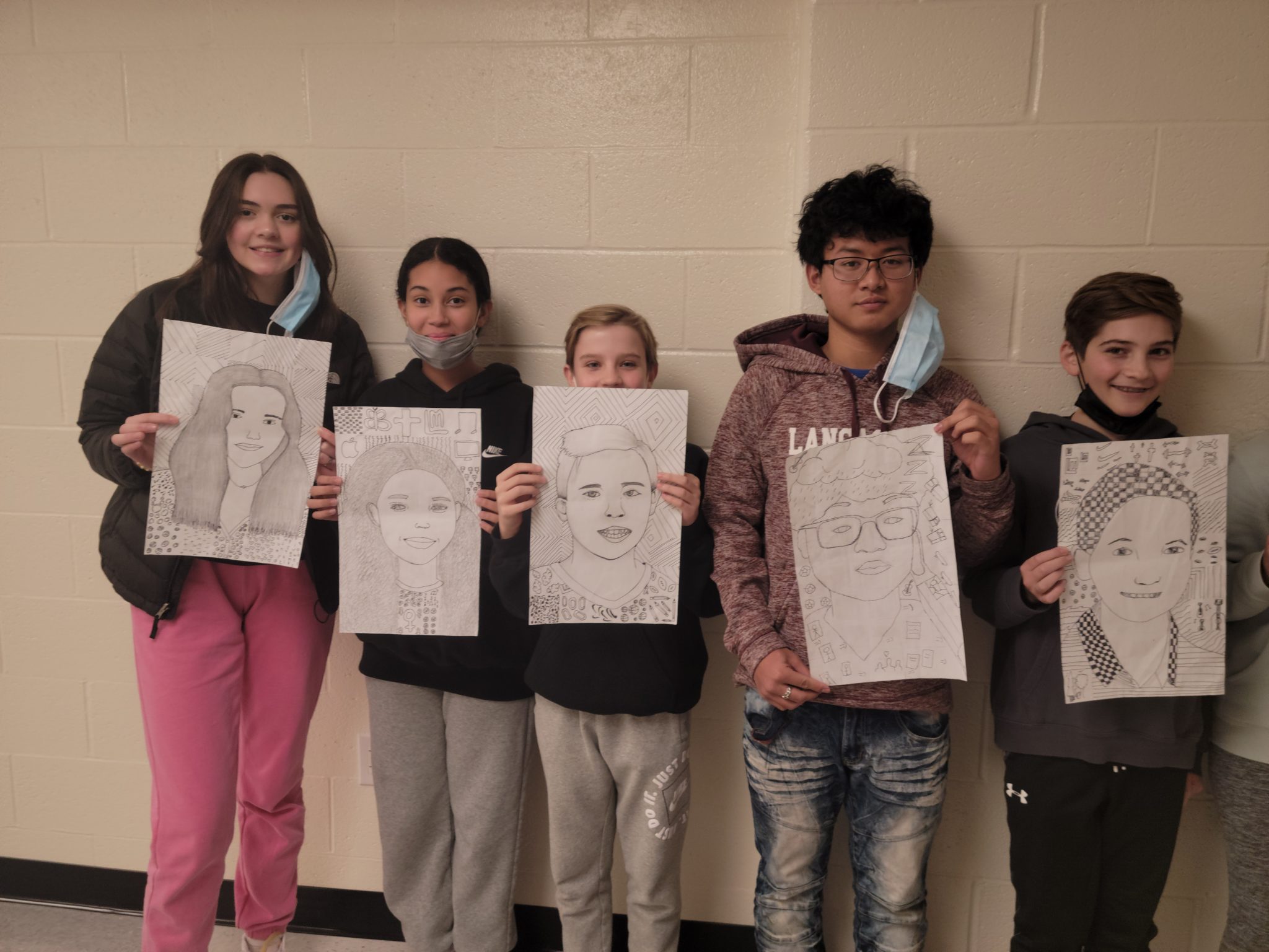 students holding up their artwork