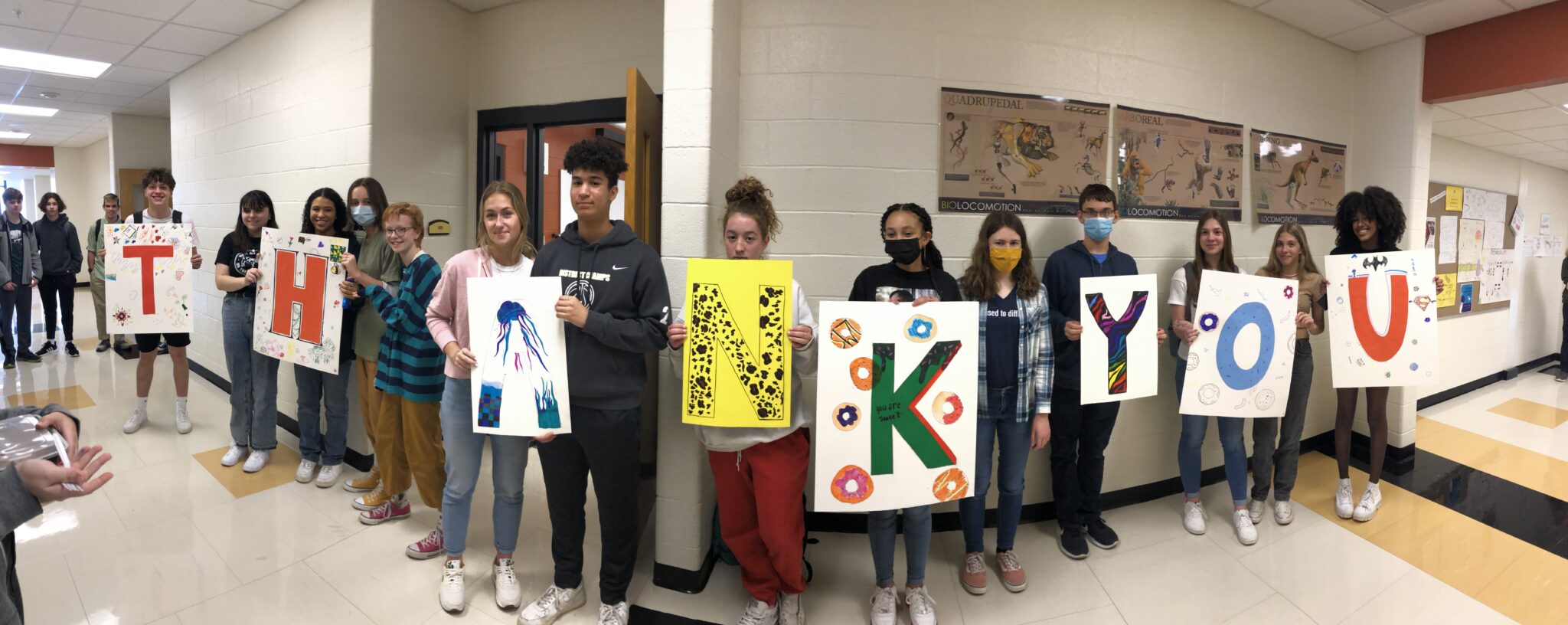 high schoolers holding thank you signs