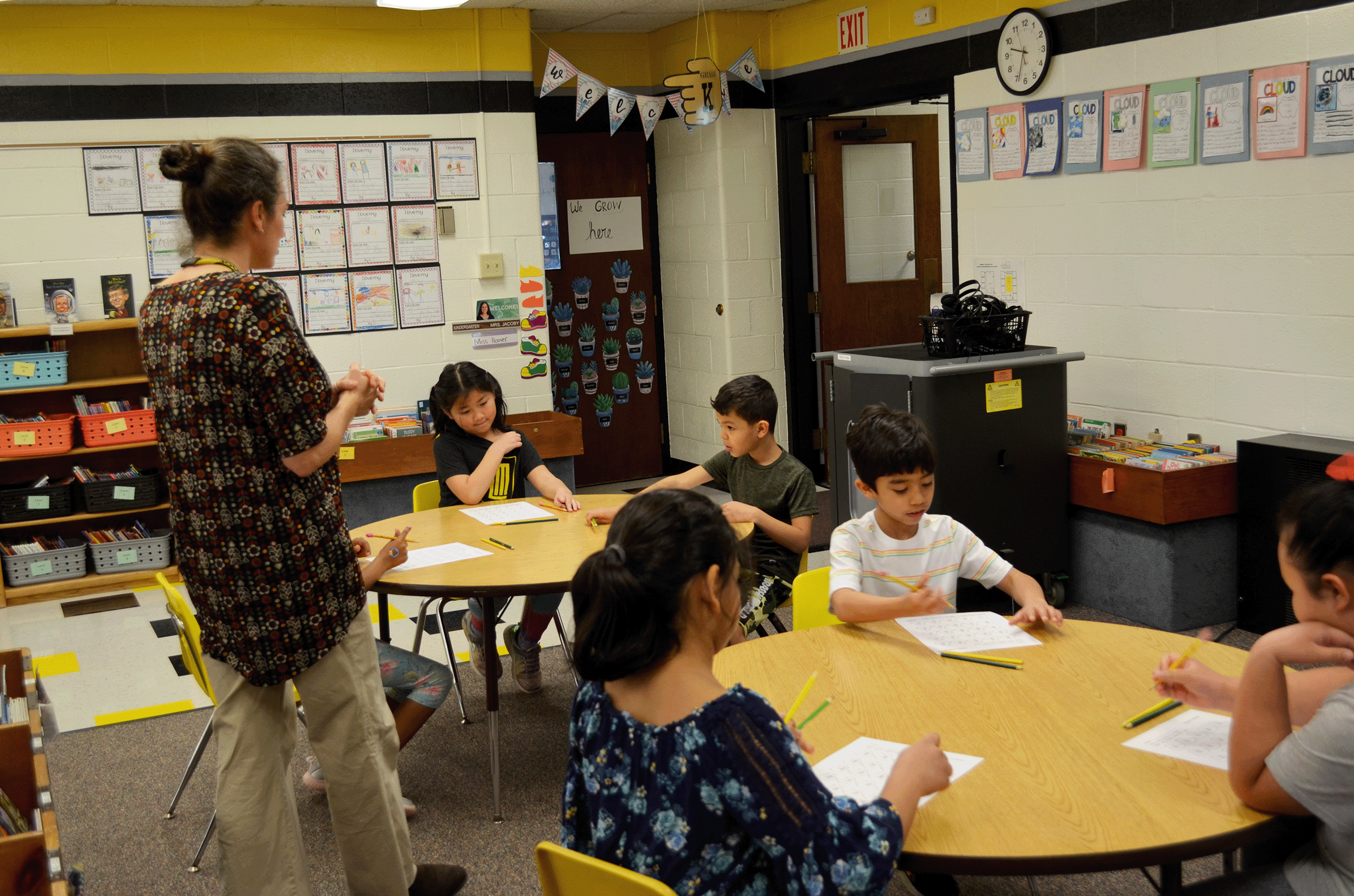 teacher helping young students with math