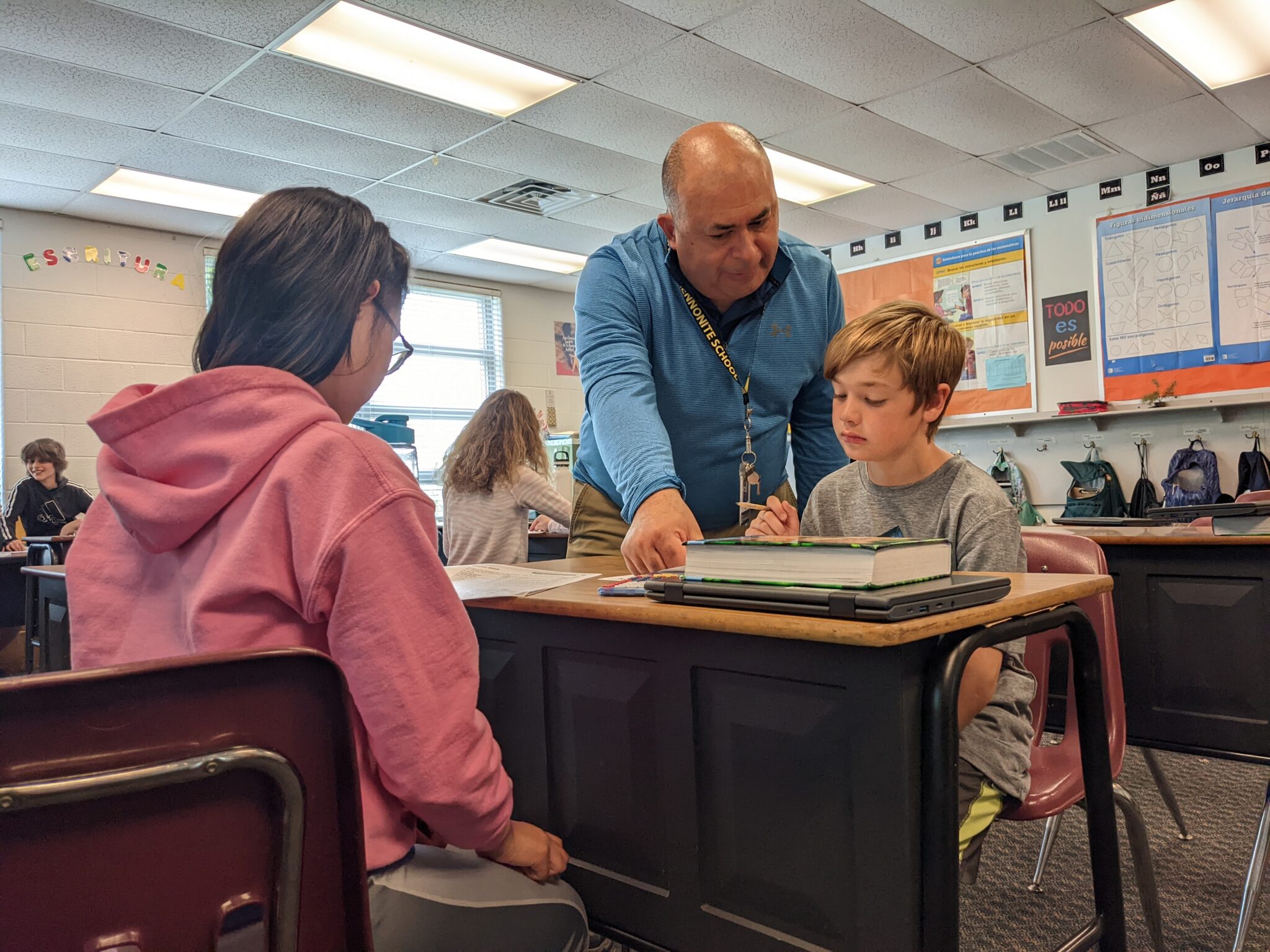 teacher helping two students