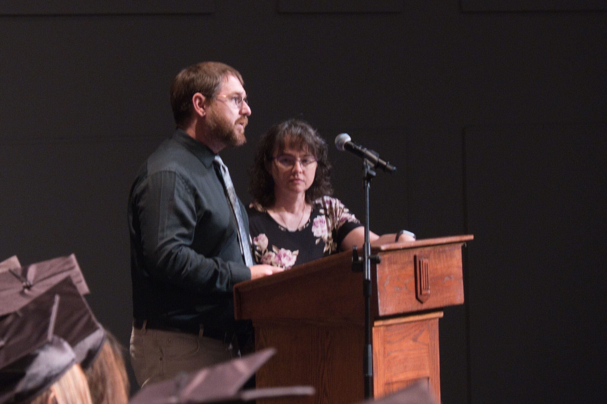 man and woman speaking at podium