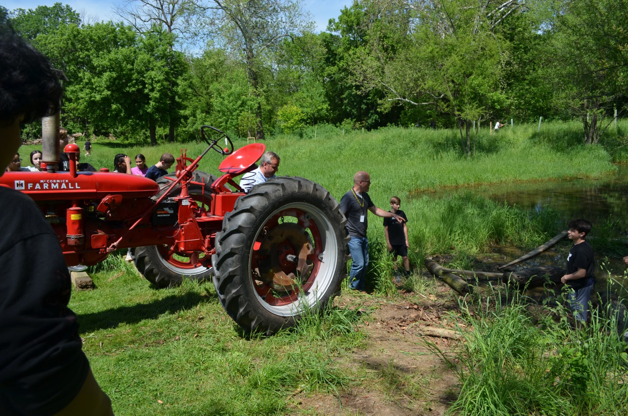 students study red tractor in the field