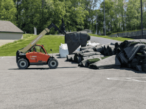 Machinery carrying away sheets of the old turf field as it was taken apart.