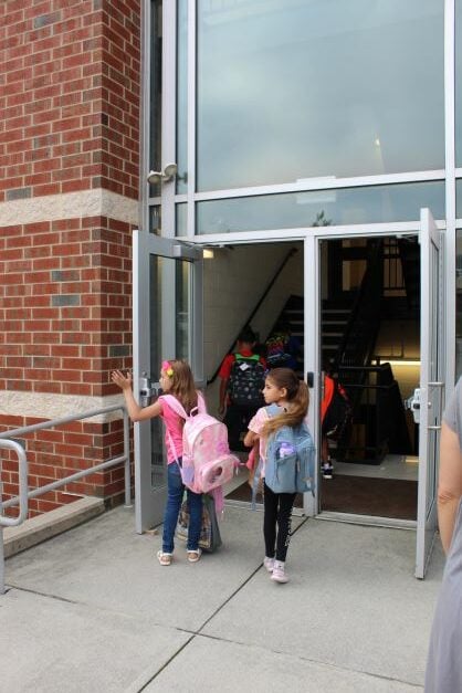 Elementary students walking into school.