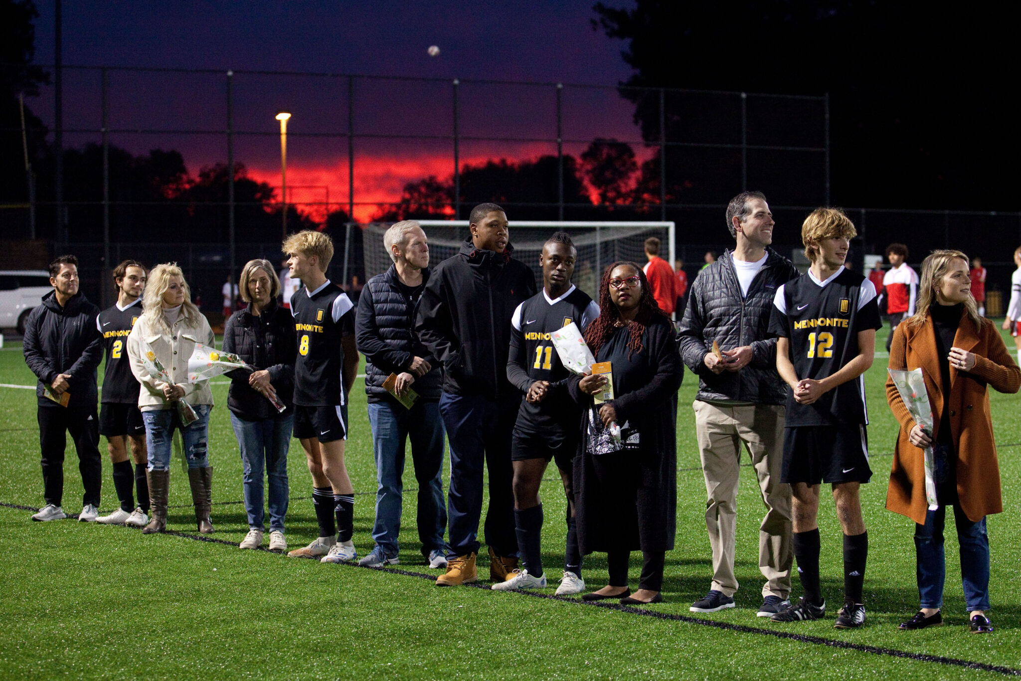 Soccer players on the field with family members