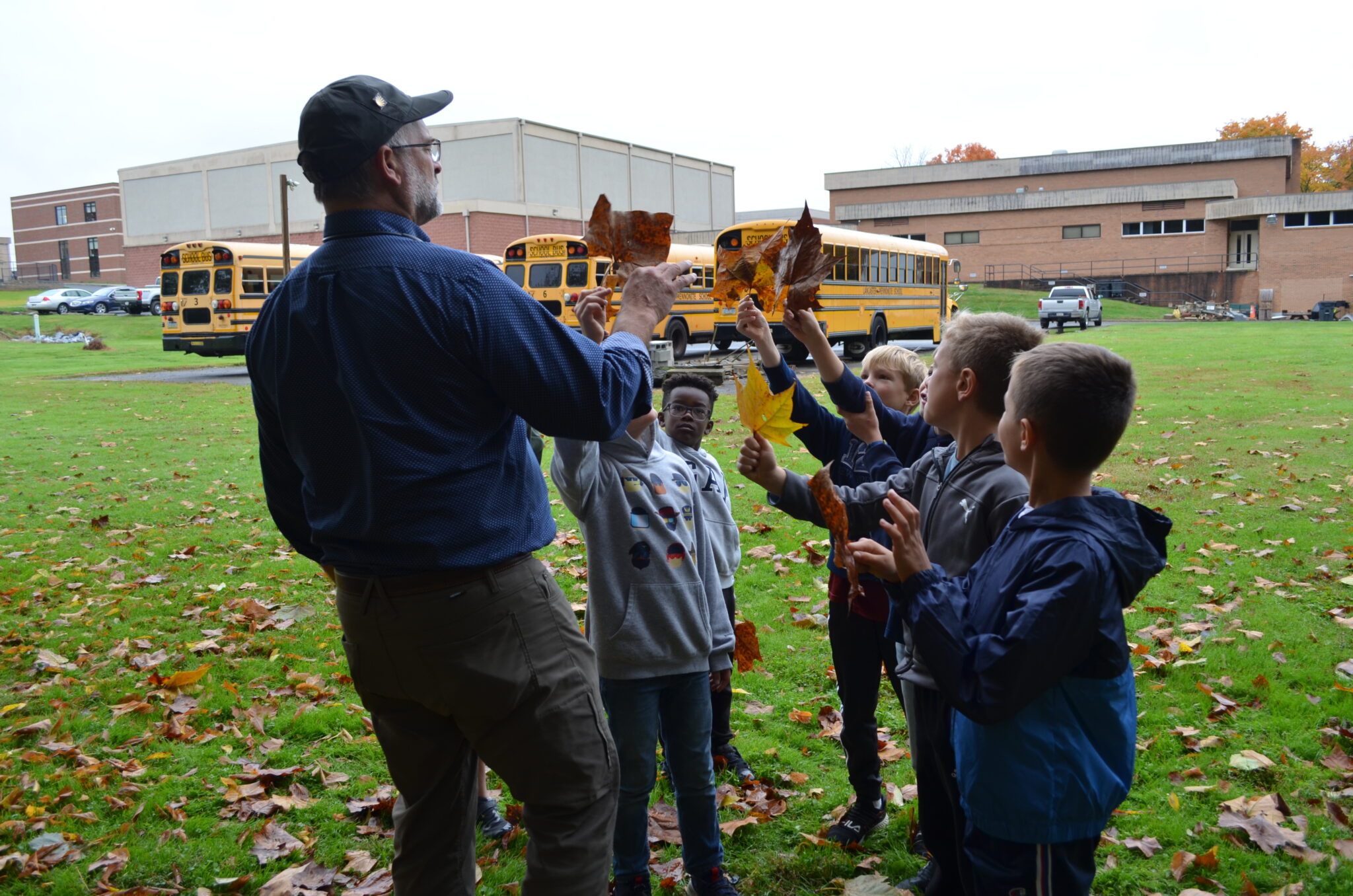 Students holding up leaves.