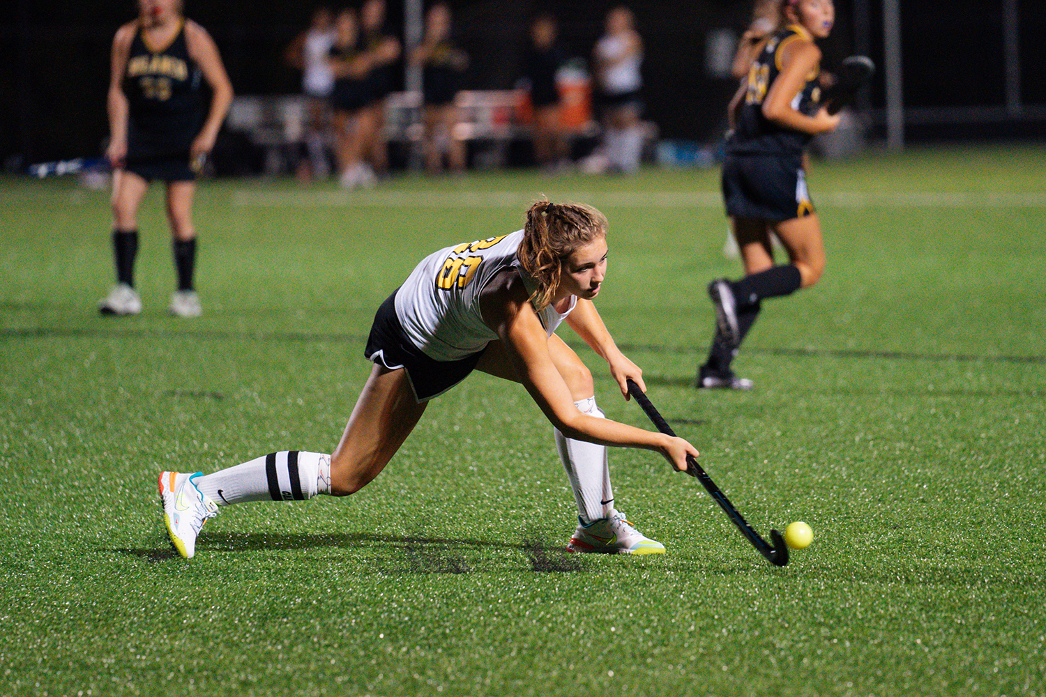 girl hitting ball with field hockey stick