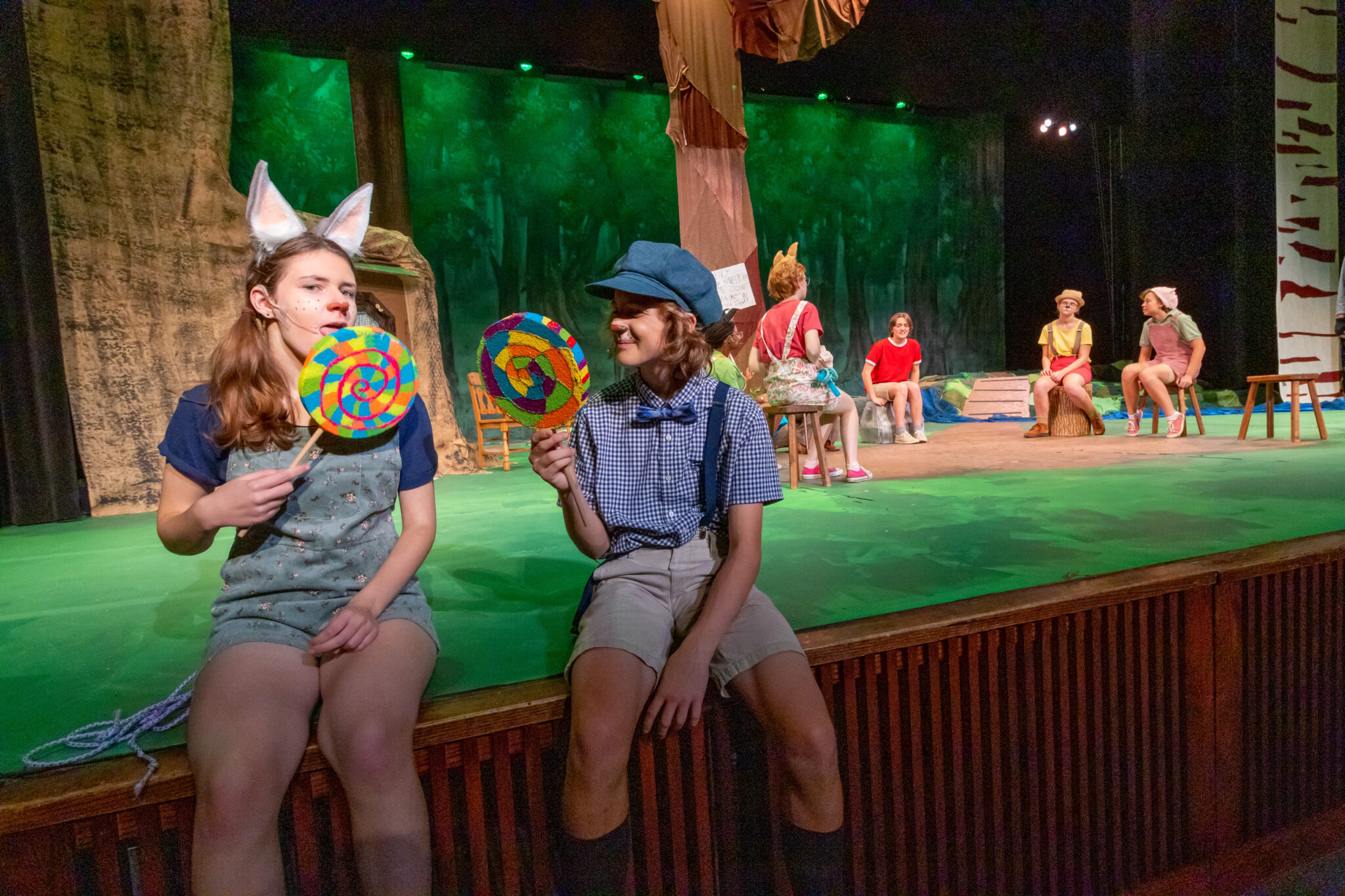 Two students on stage with other students in the background