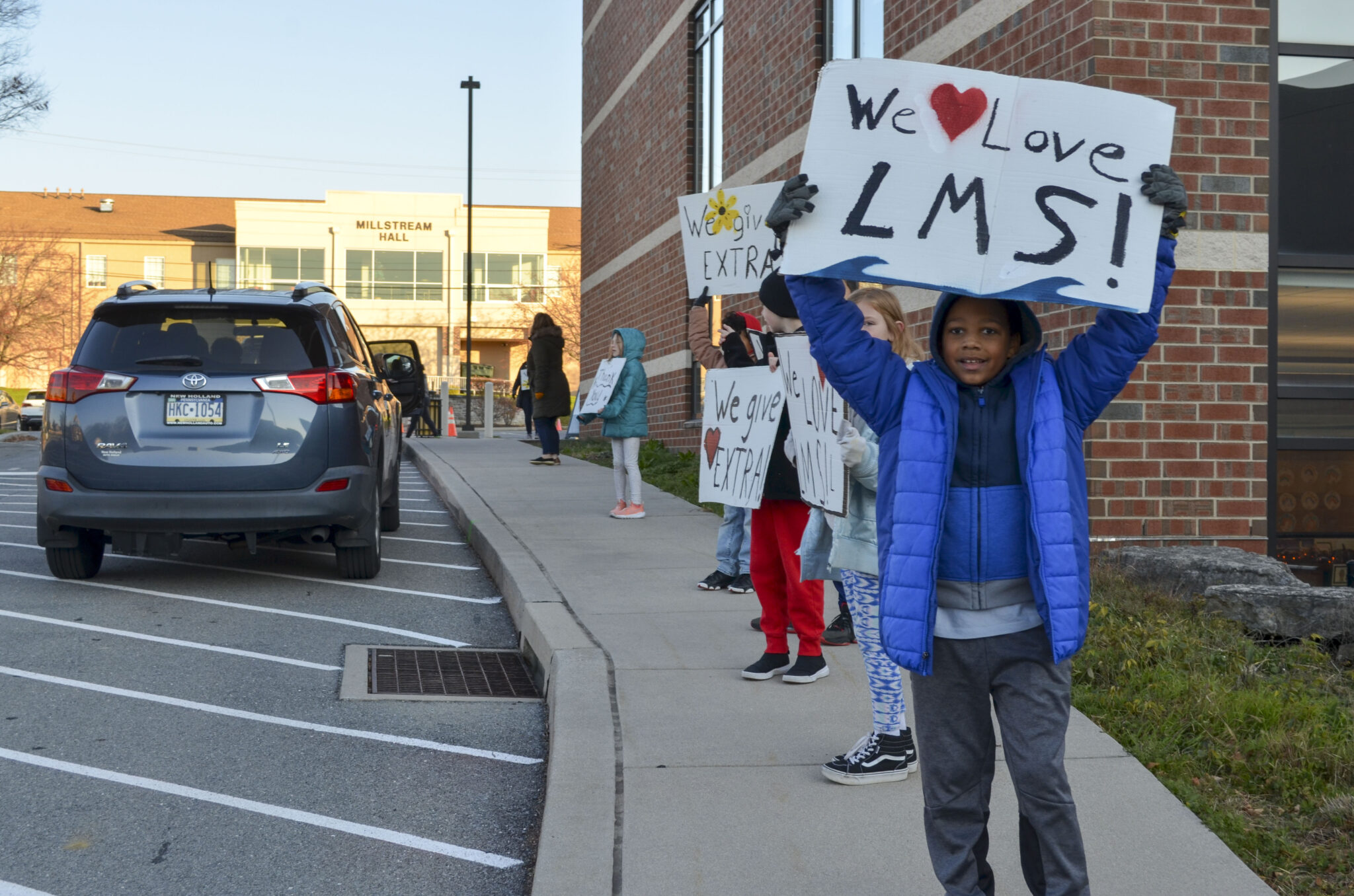 LM students holding up signs during morning drop off.