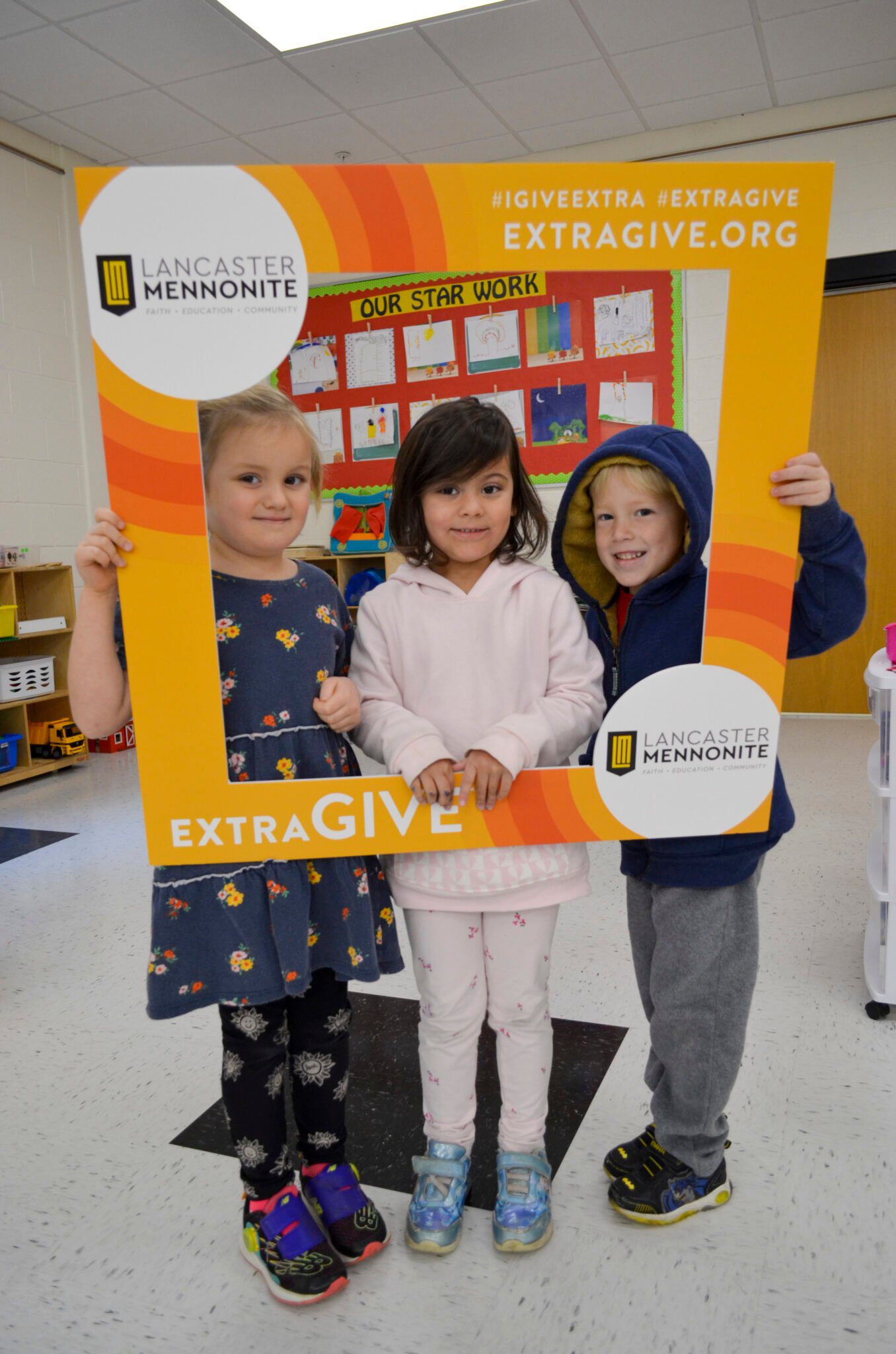 Elementary students holding up Extragive sign