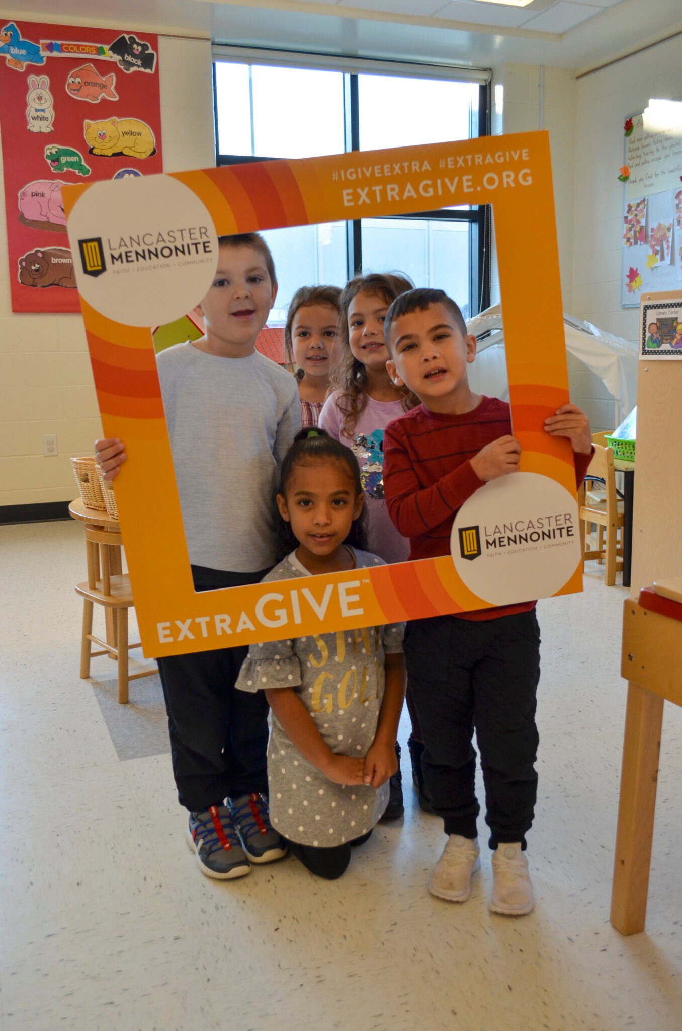 Elementary students holding up Extragive sign