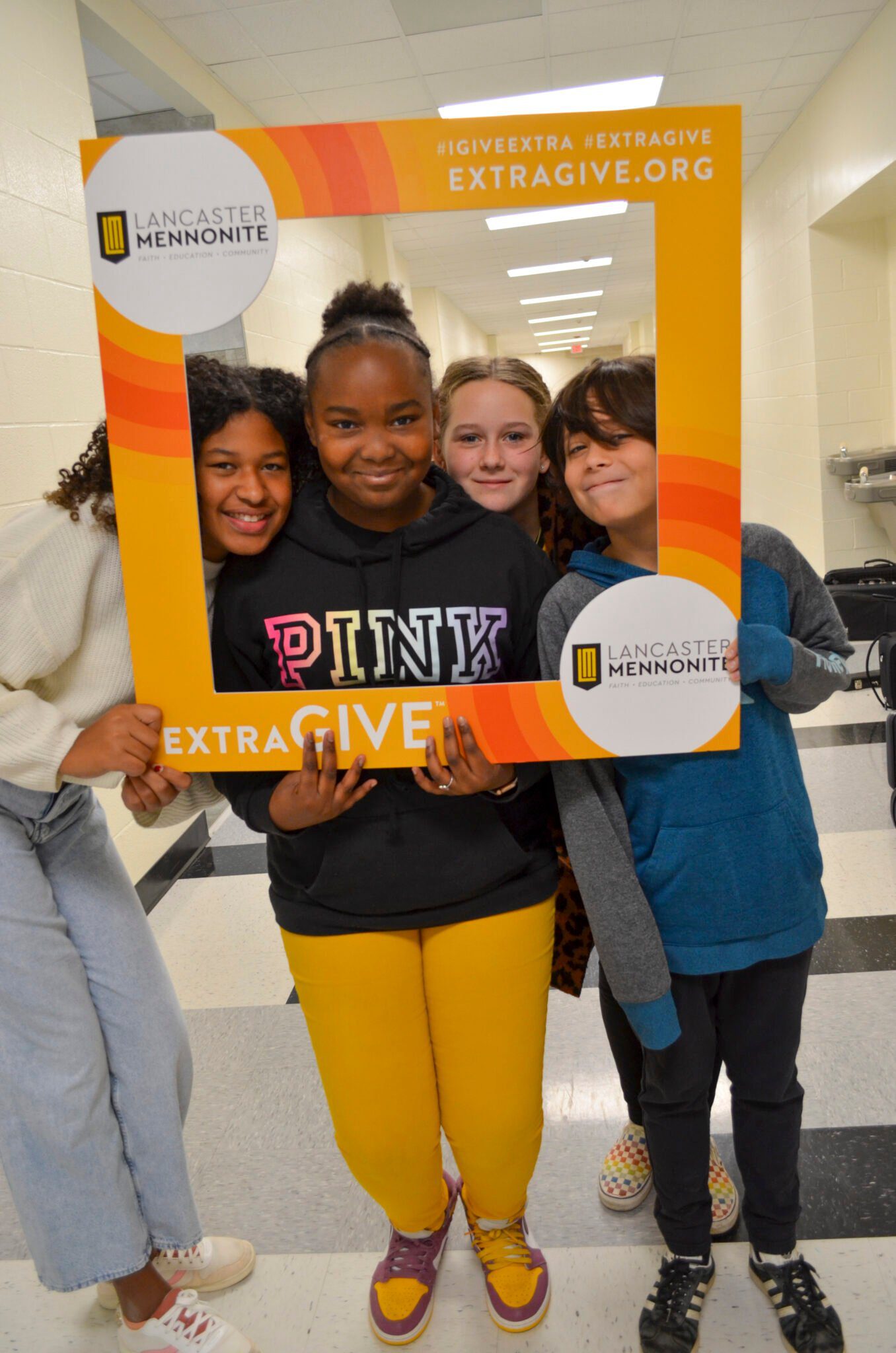 Students in the hallway with Extragive sign.