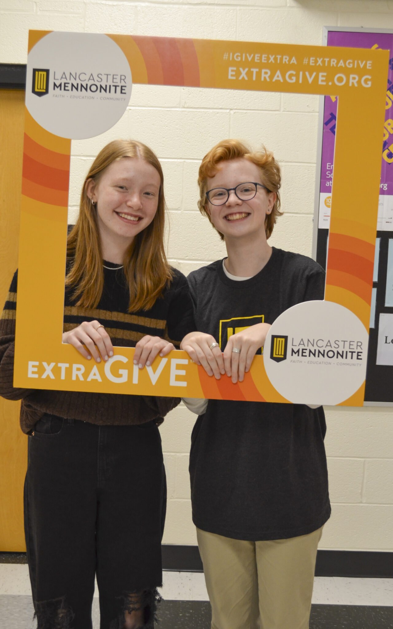 Two LM students with Extragive sign.